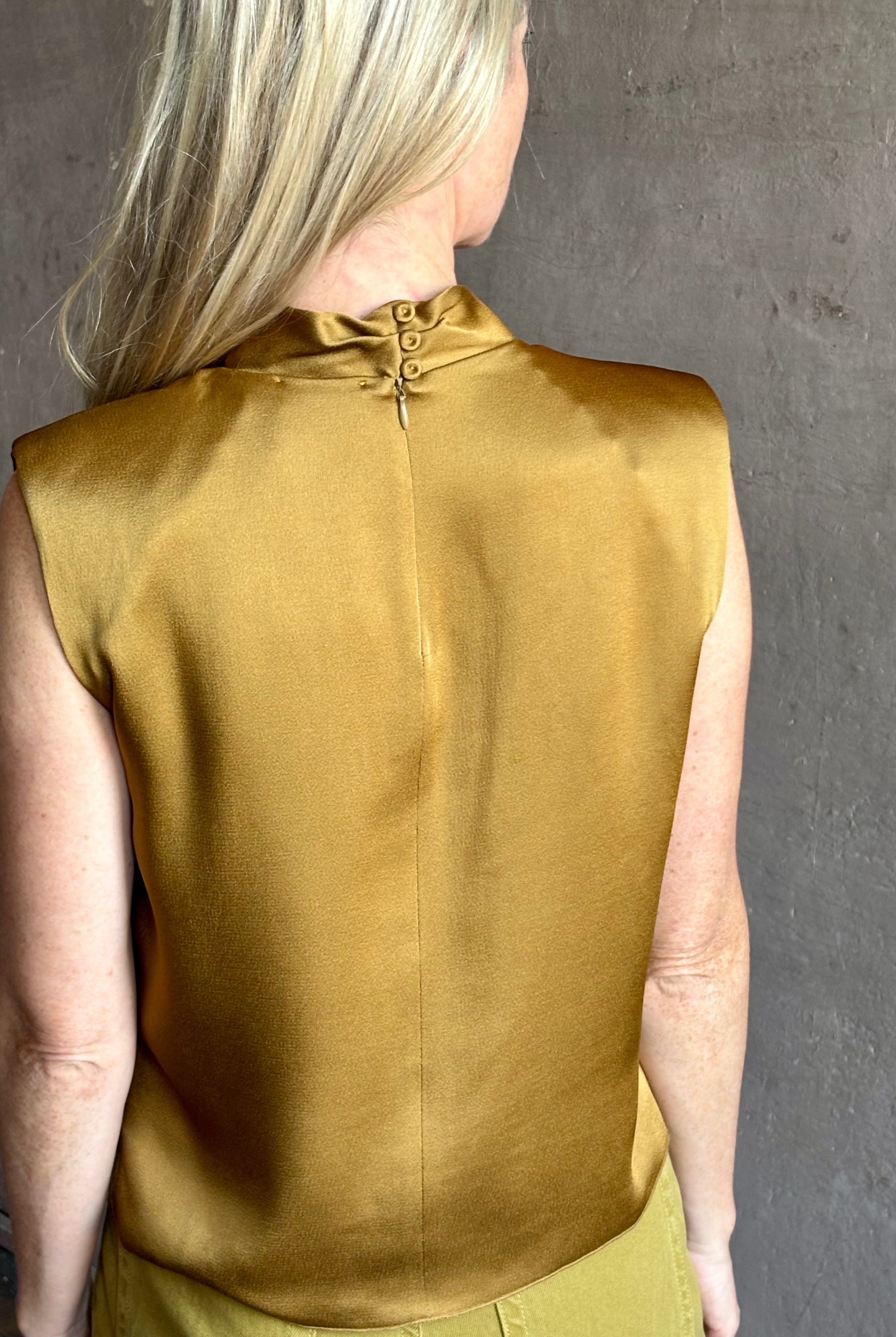 Image of mature woman wearing luxury Italian designer FORTE FORTE Envers Satin Crater-Neck sleeveless Shirt in matte Antique Gold