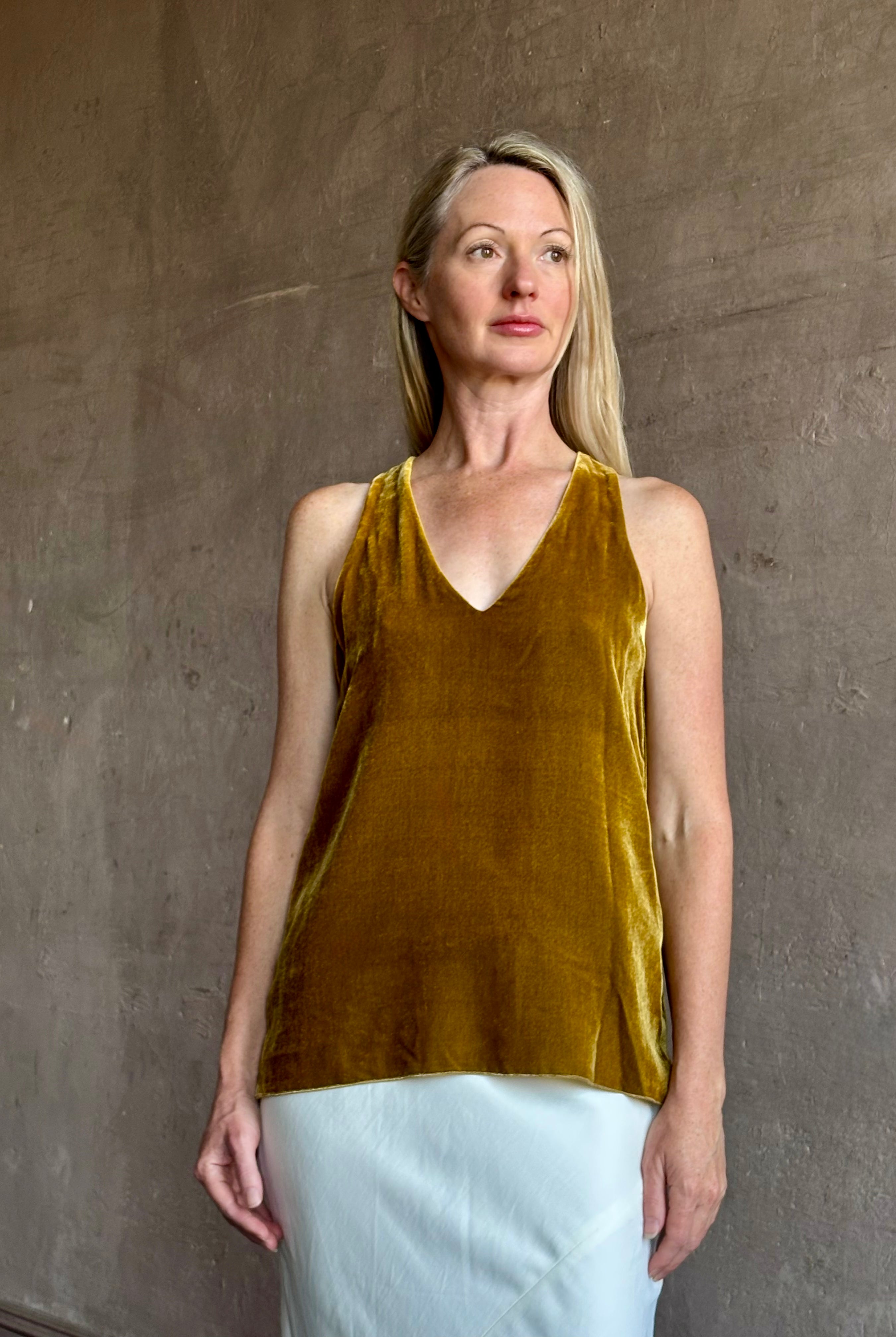 Image of mature woman wearing luxury Italian designer FORTE FORTE Plain sleeveless Velvet V Neck Top in Antique Gold with exquisite draping