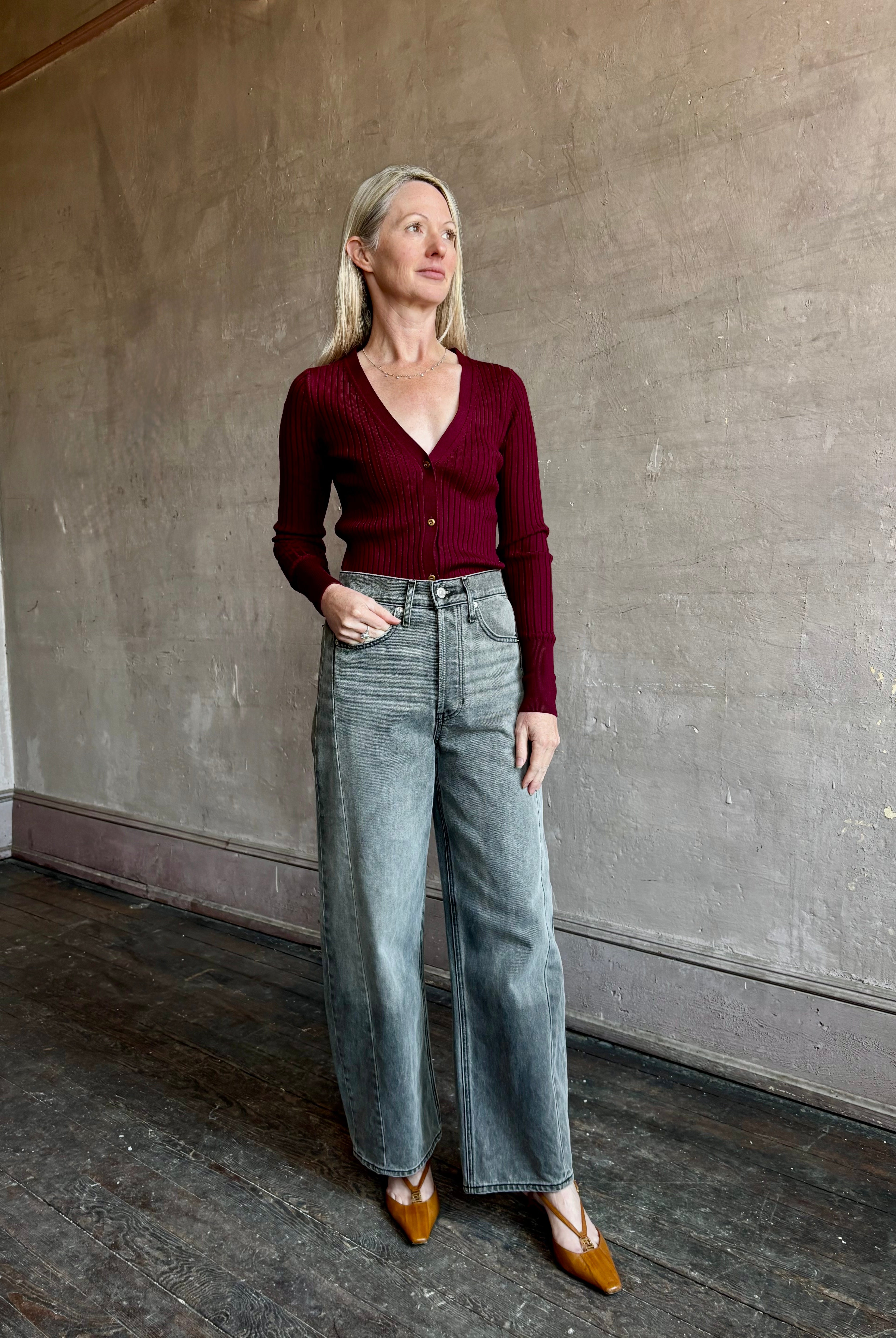 Image of woman wearing premium virgin wool cardigan with v-neck, ribbed texture and long sleeves in a rich burgundy