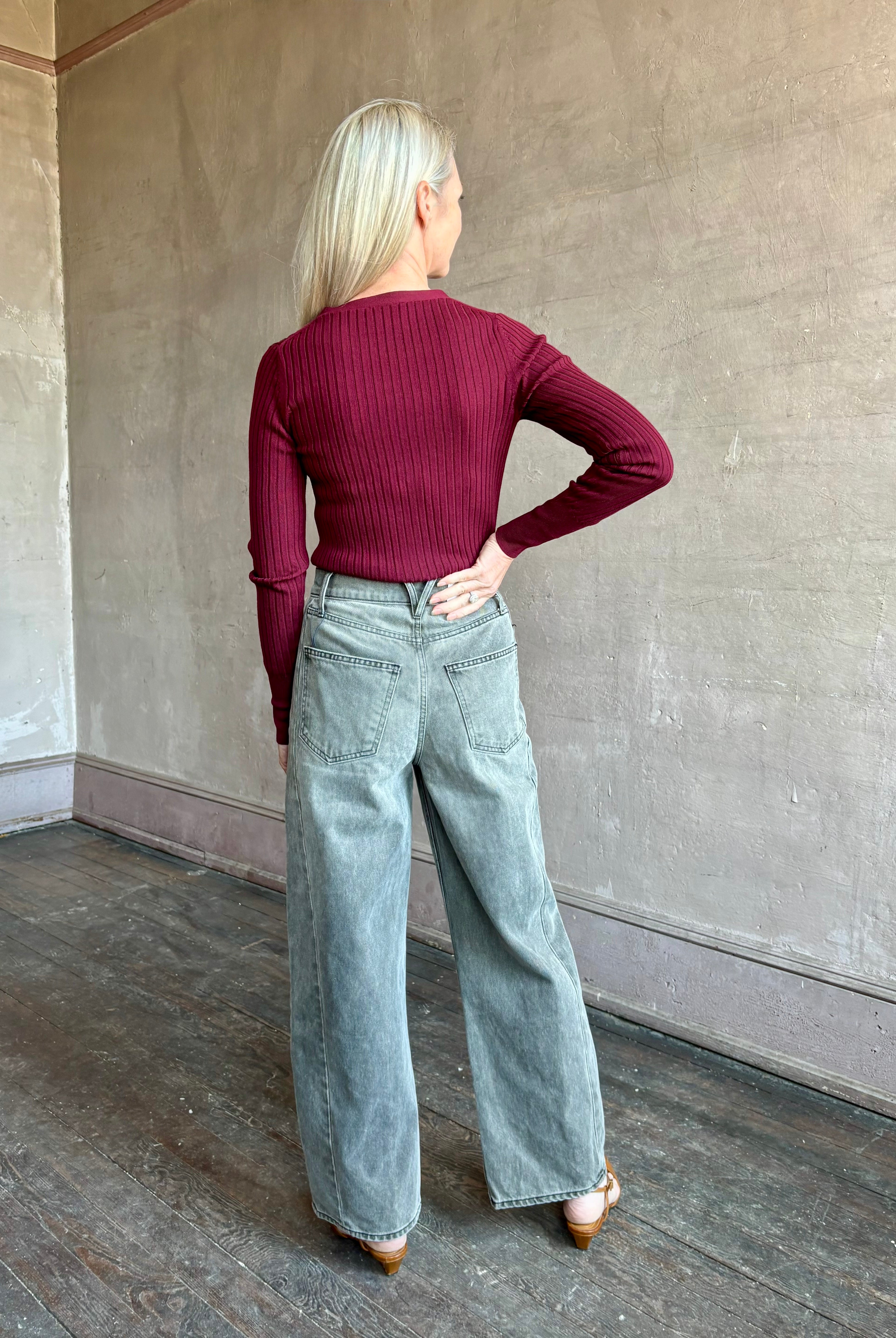 Image of woman wearing premium virgin wool cardigan with v-neck, ribbed texture and long sleeves in a rich burgundy
