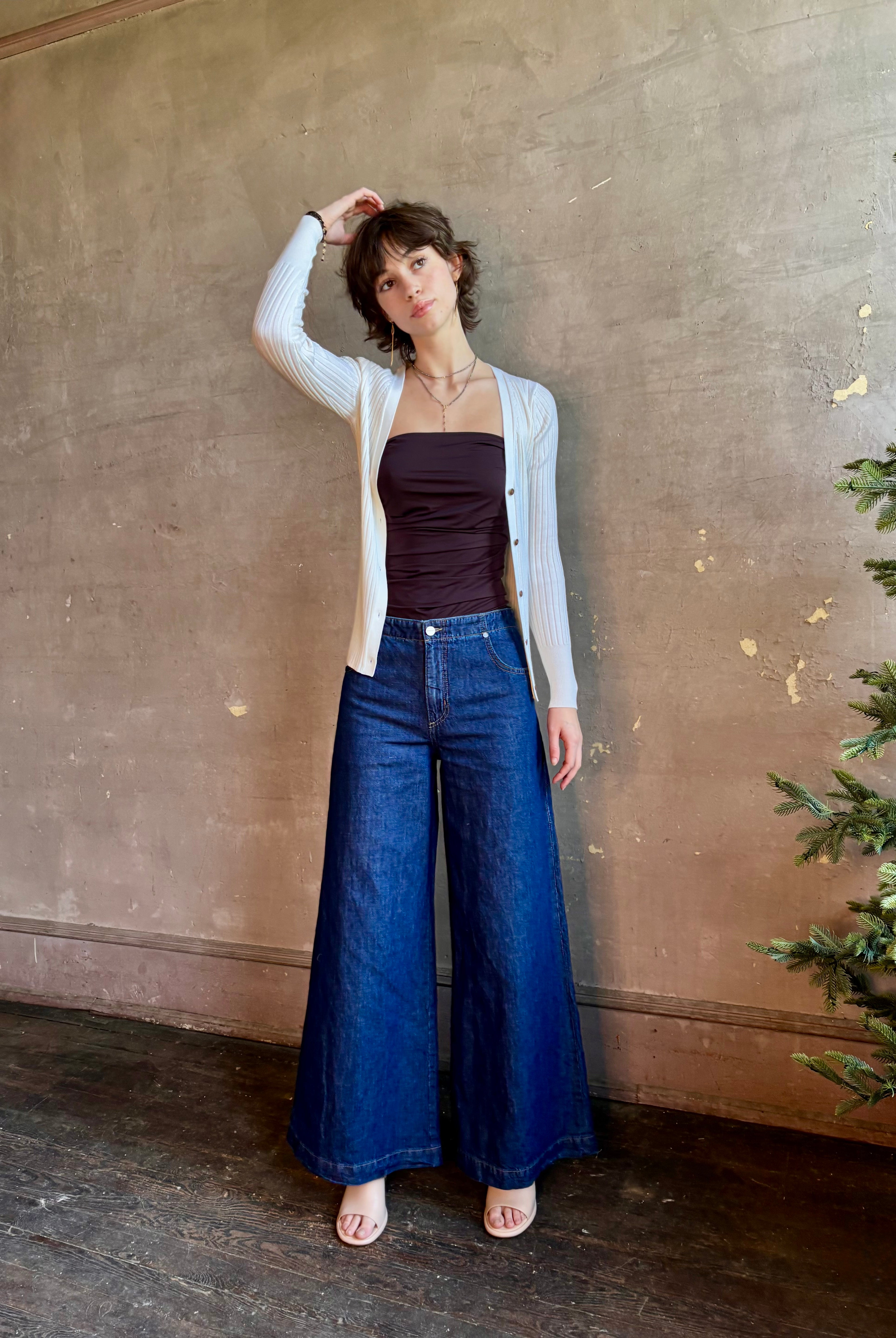 Woman wearing luxury Italian knitwear by FORTE FORTE Superfine Merino Ribbed Cardigan in Neve off-white with v-neck, button front and long sleeves