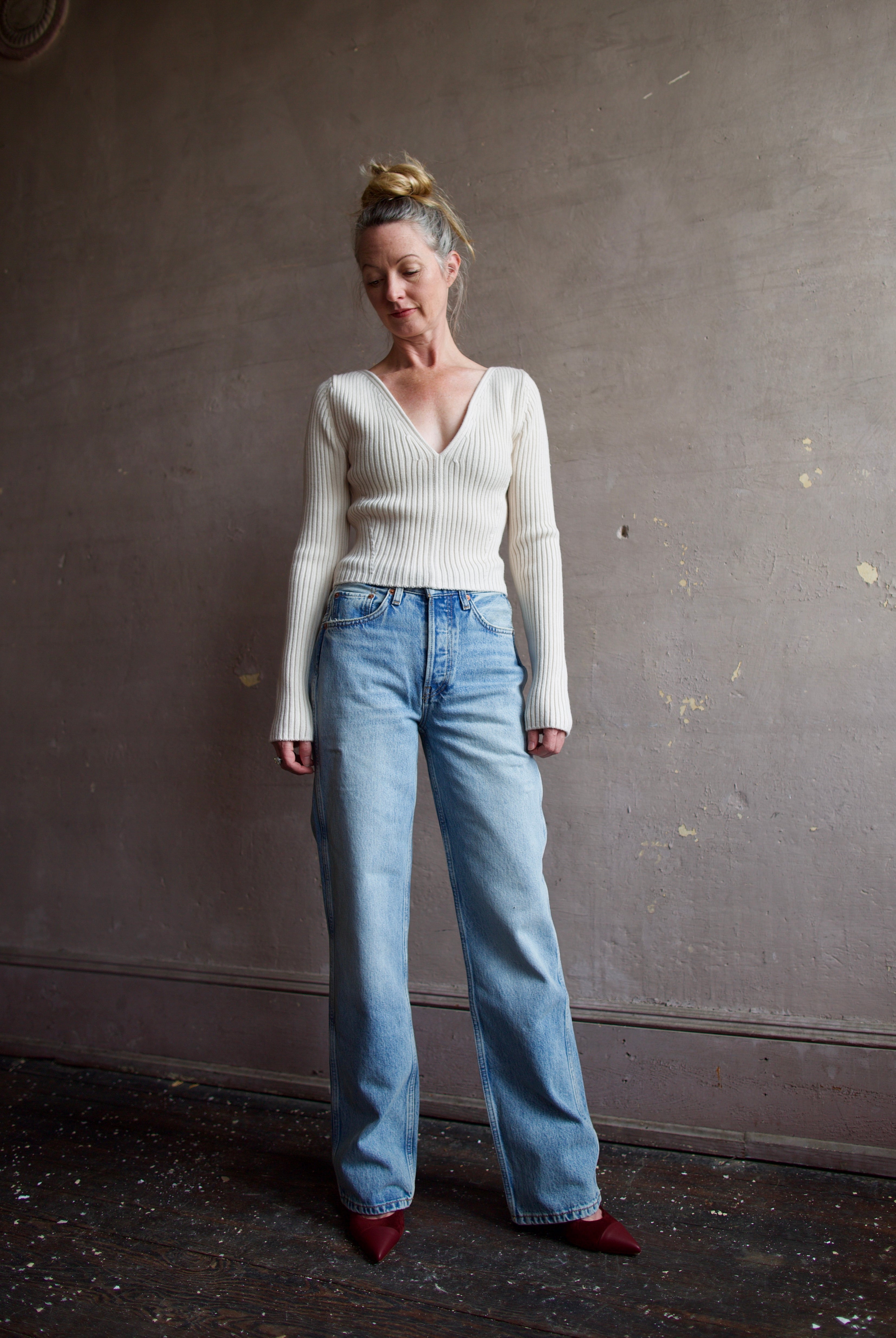 Image featuring a woman wearing the Forte Forte Deep Neckline Ribbed Stretch Merino Sweater with a v-neckline and a cropped fit.