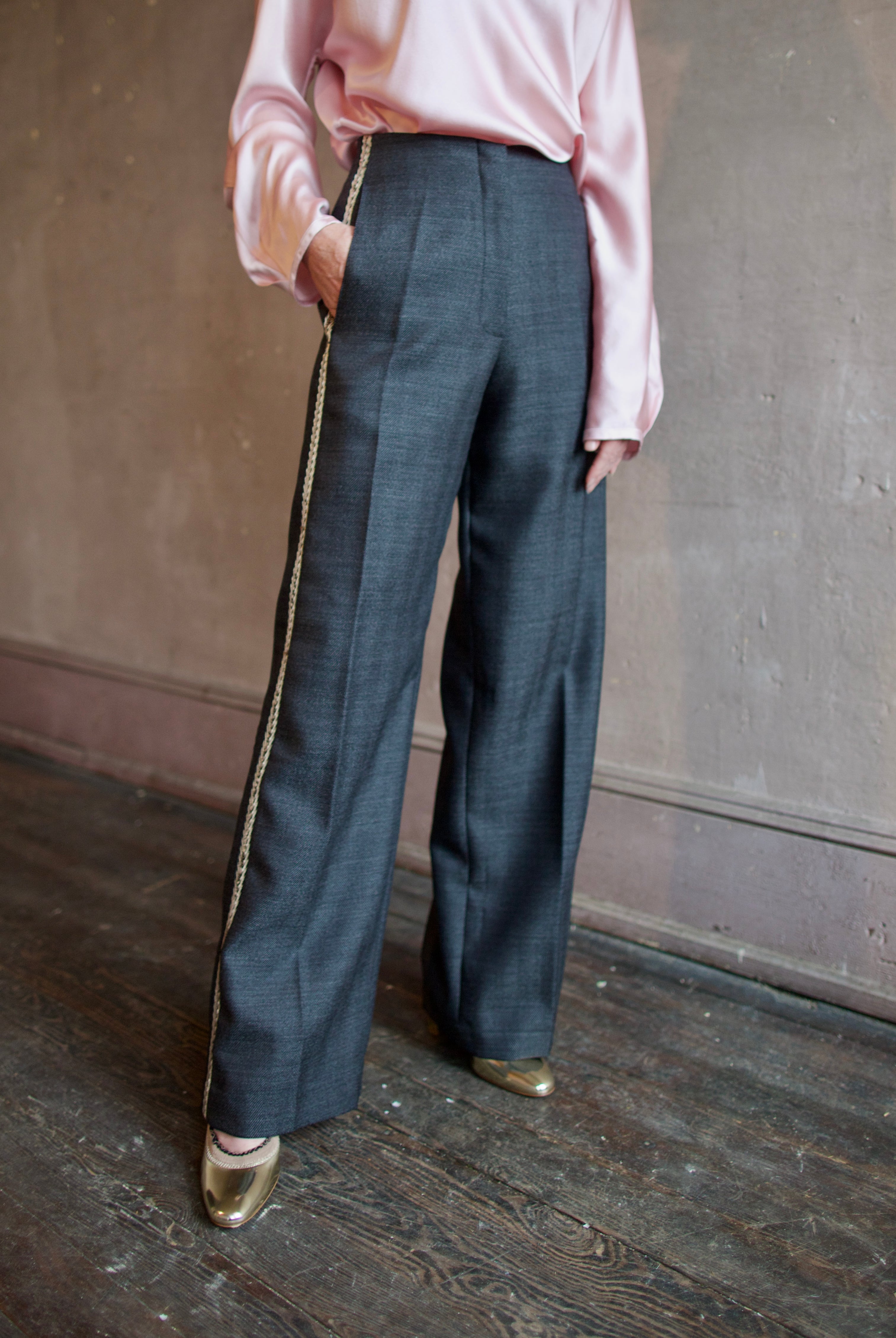 Image featuring a woman wearing herringbone pants by Forte Forte with a mid rise, straight leg and beaded embellishment along one side.
