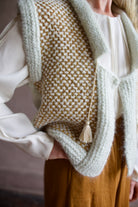 Senior model wearing designer clothing Ulla Johnson white blouse with Forte Forte  skirt and mint green layering sweater vest
