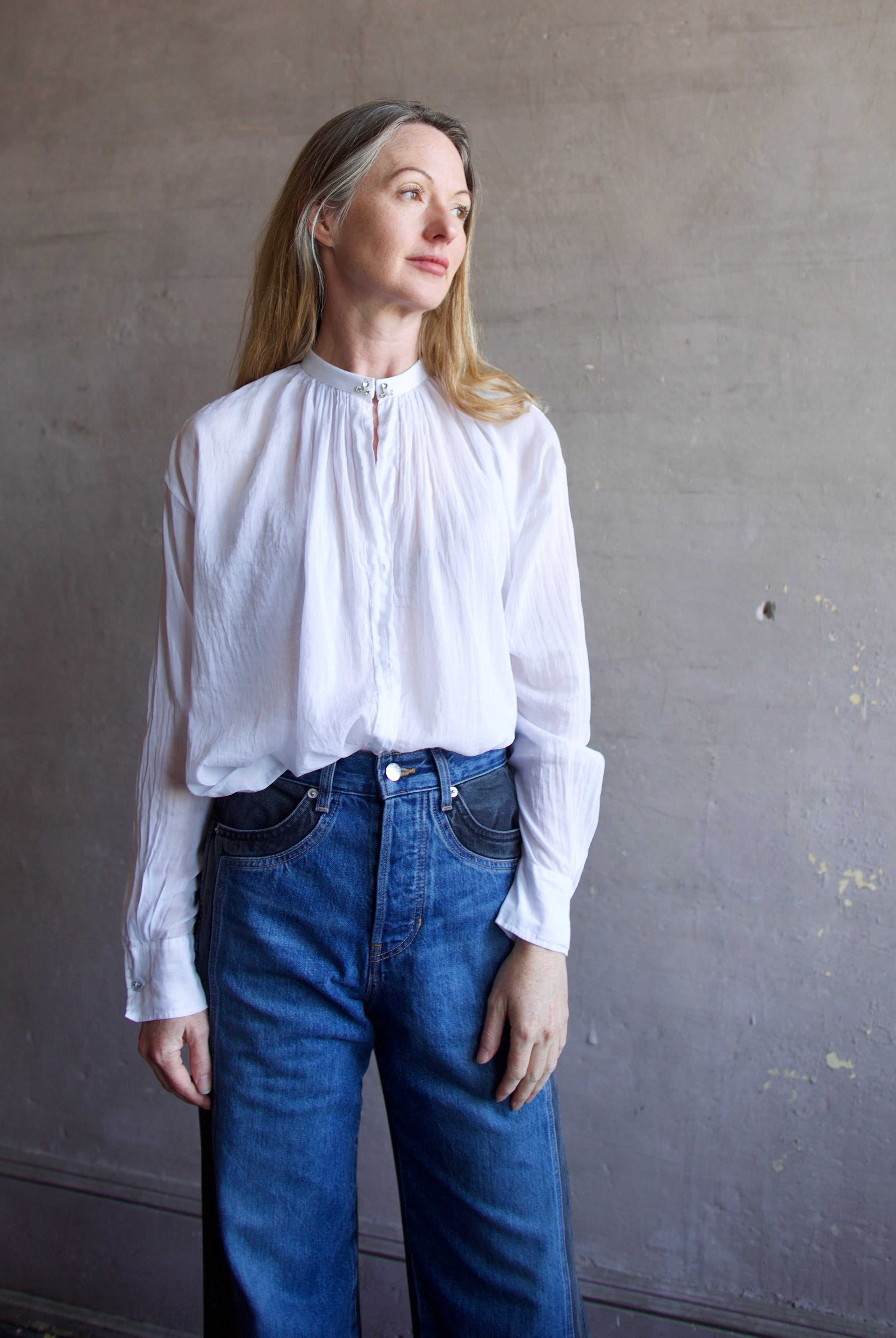 Image featuring a woman wearing the voile bohemian shirt by Forte Forte with a hook and eye closure and crystal embellishment at the mandarin collar and sleeve button.