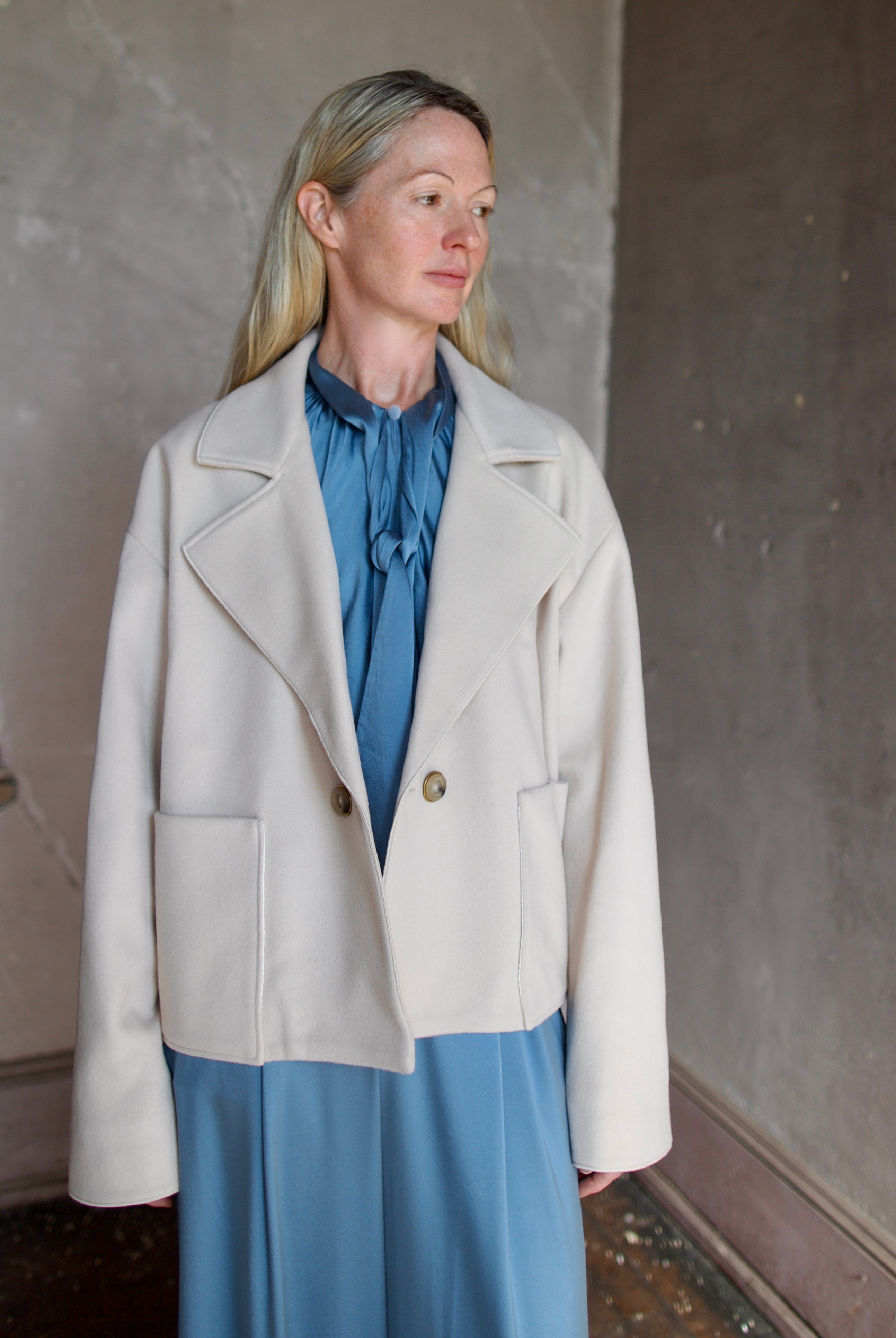 Model wearing expertly tailored Forte Forte beige jacket in premium virgin wool and cashmere with front pockets and button closure