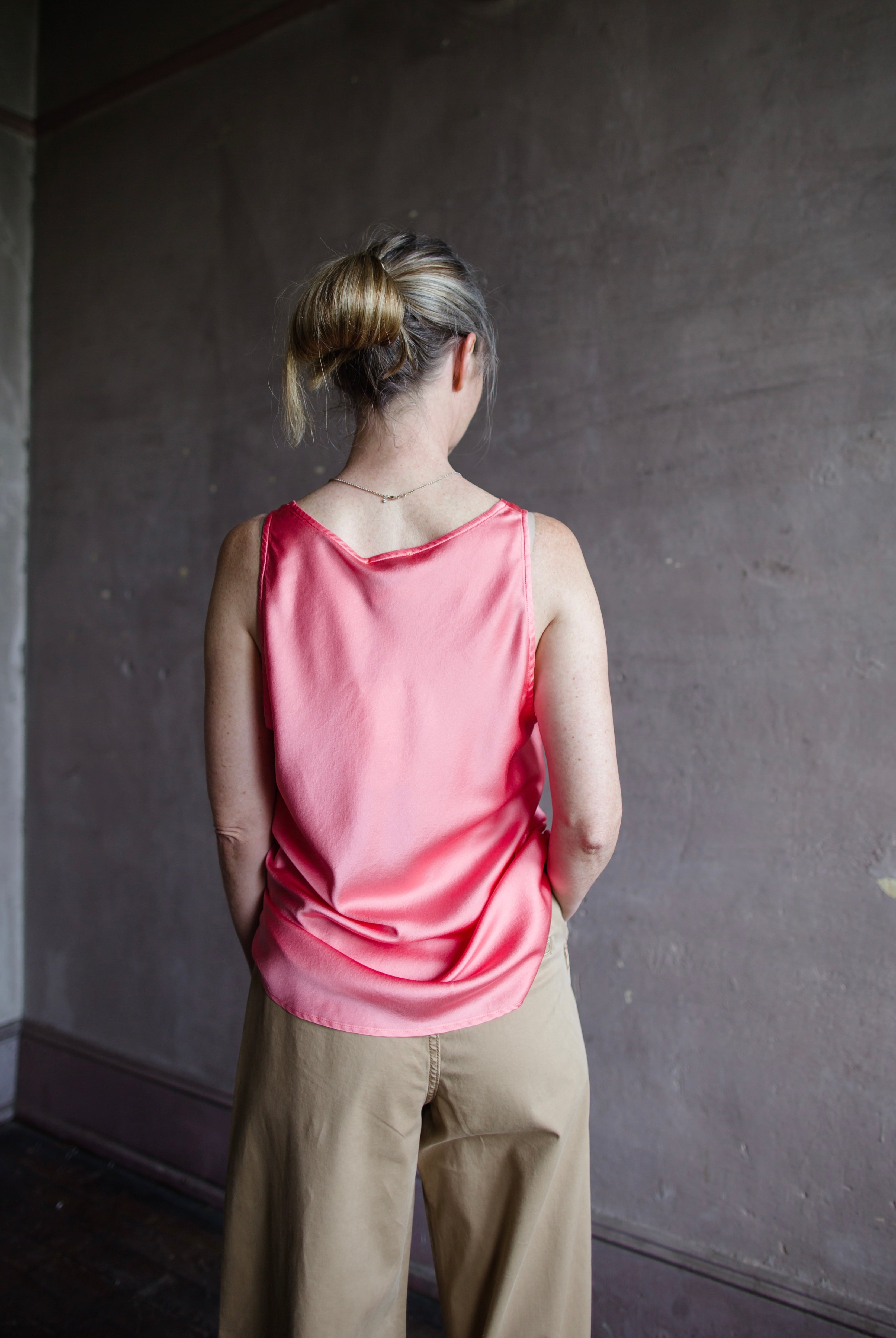 Image featuring a woman wearing the pink heavy satin silk tank by Forte Forte with a scoop neckline and relaxed fit.