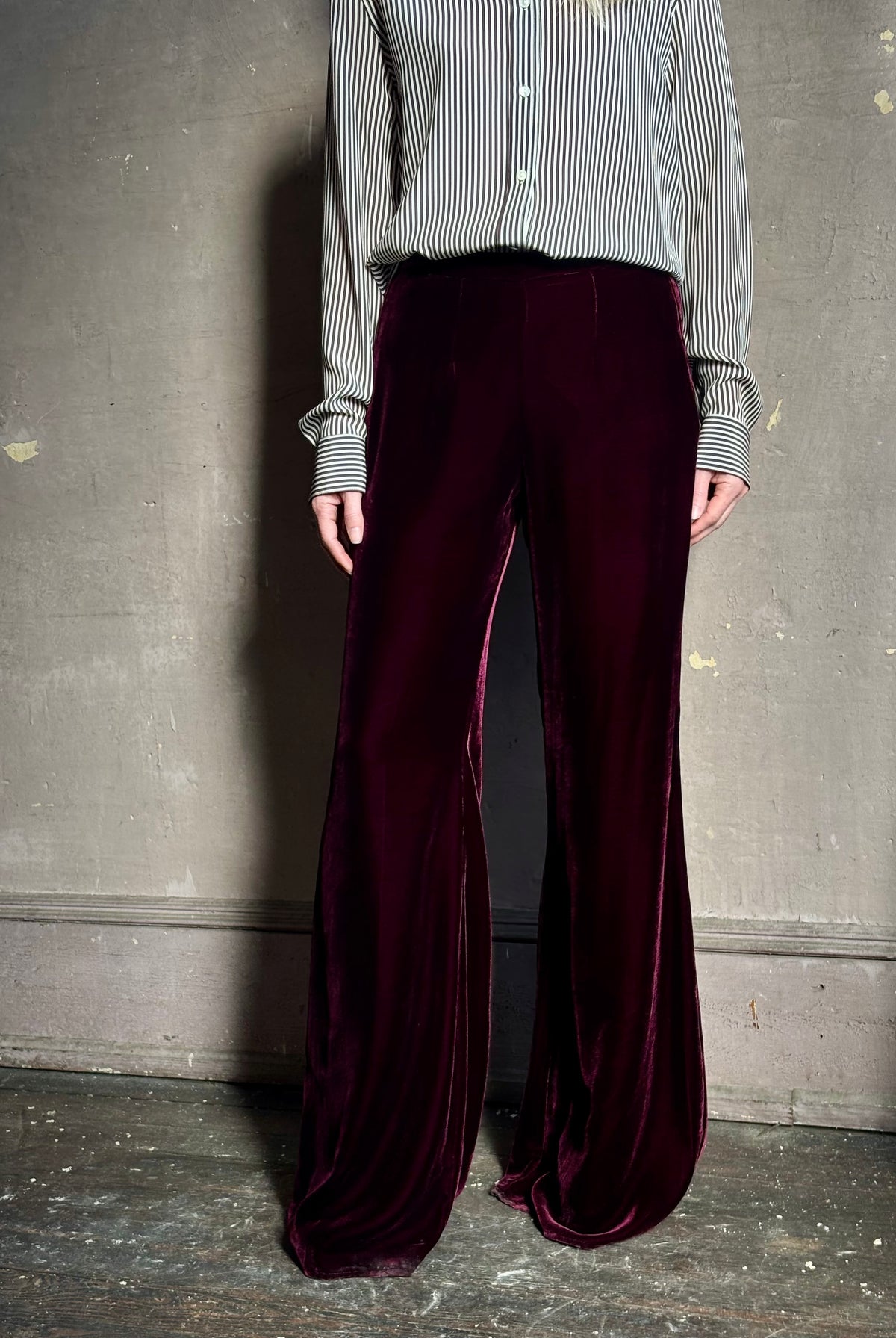 Close up of Forte_Forte Plain Velvet Flare Pants in Burgundy fitted flat front with tailored waistband fluid leg full length consealed side seam zipper