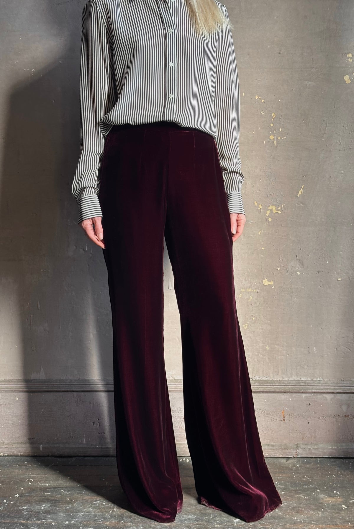 Close up of Forte_Forte Plain Velvet Flare Pants in Burgundy velvet fitted flat front fluid flare leg consealed side seam zipper