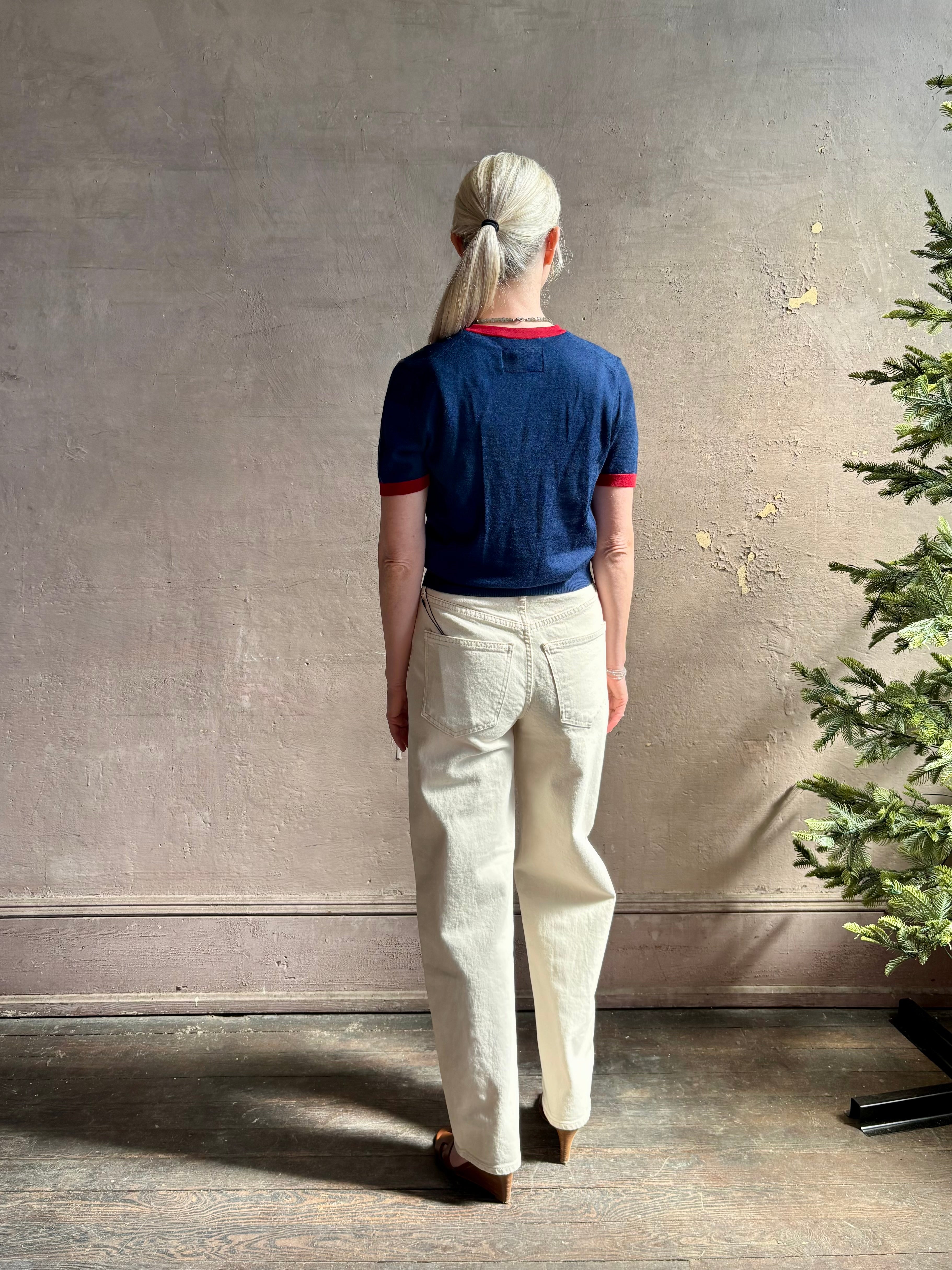 Mature woman wearing women's designer cashmere Airy short sleeve Ringer Tee from Guest in Residence rendered in a navy body with carmine ringer detailing and crafted from 100% lightweight cashmere with a crew neckline