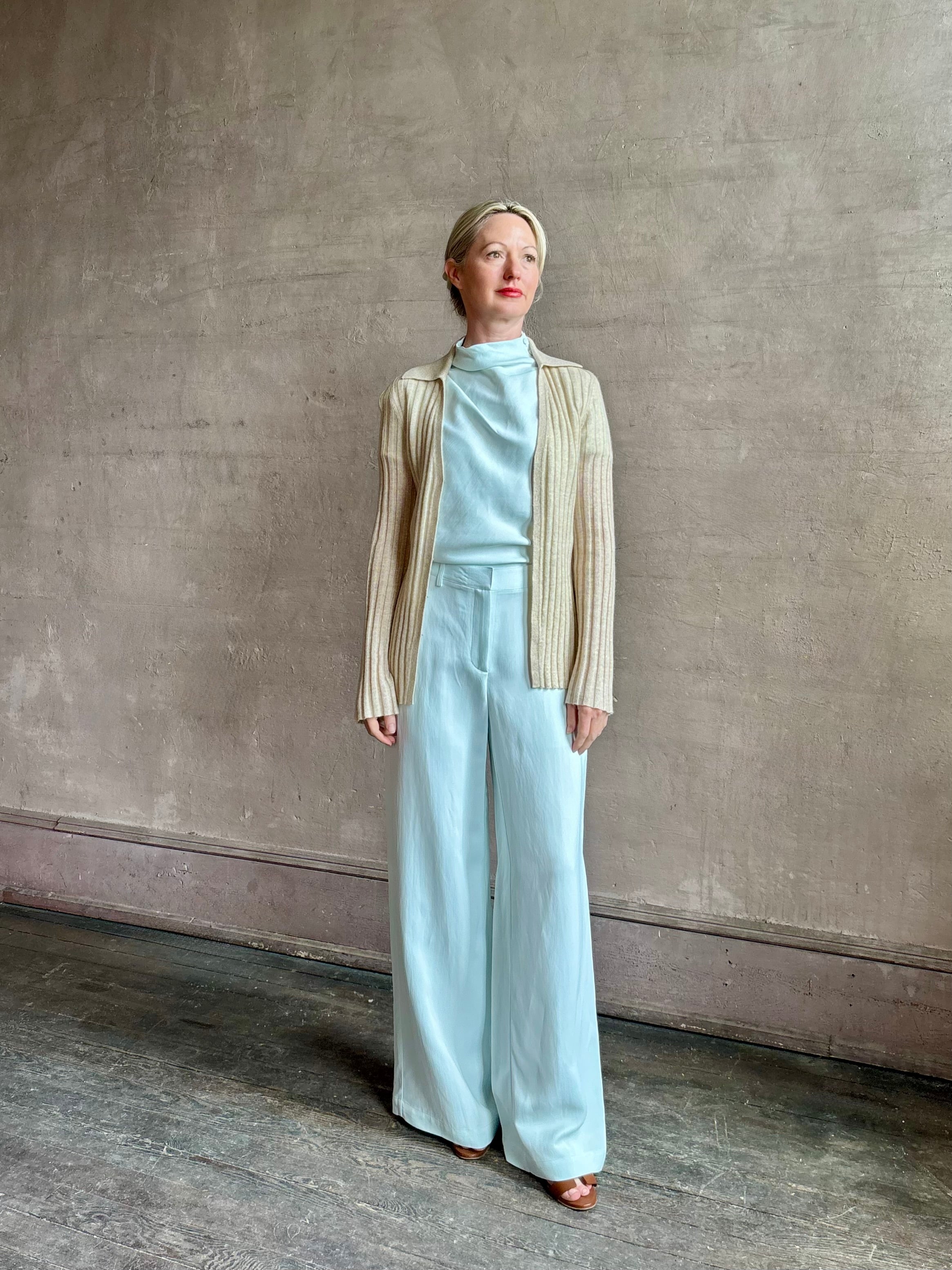 Image of mature woman wearing premium cashmere linen GUEST IN RESIDENCE Breezy Cardigan in Sandstone beige with long sleeves hook and eye front closure and ribbed texture
