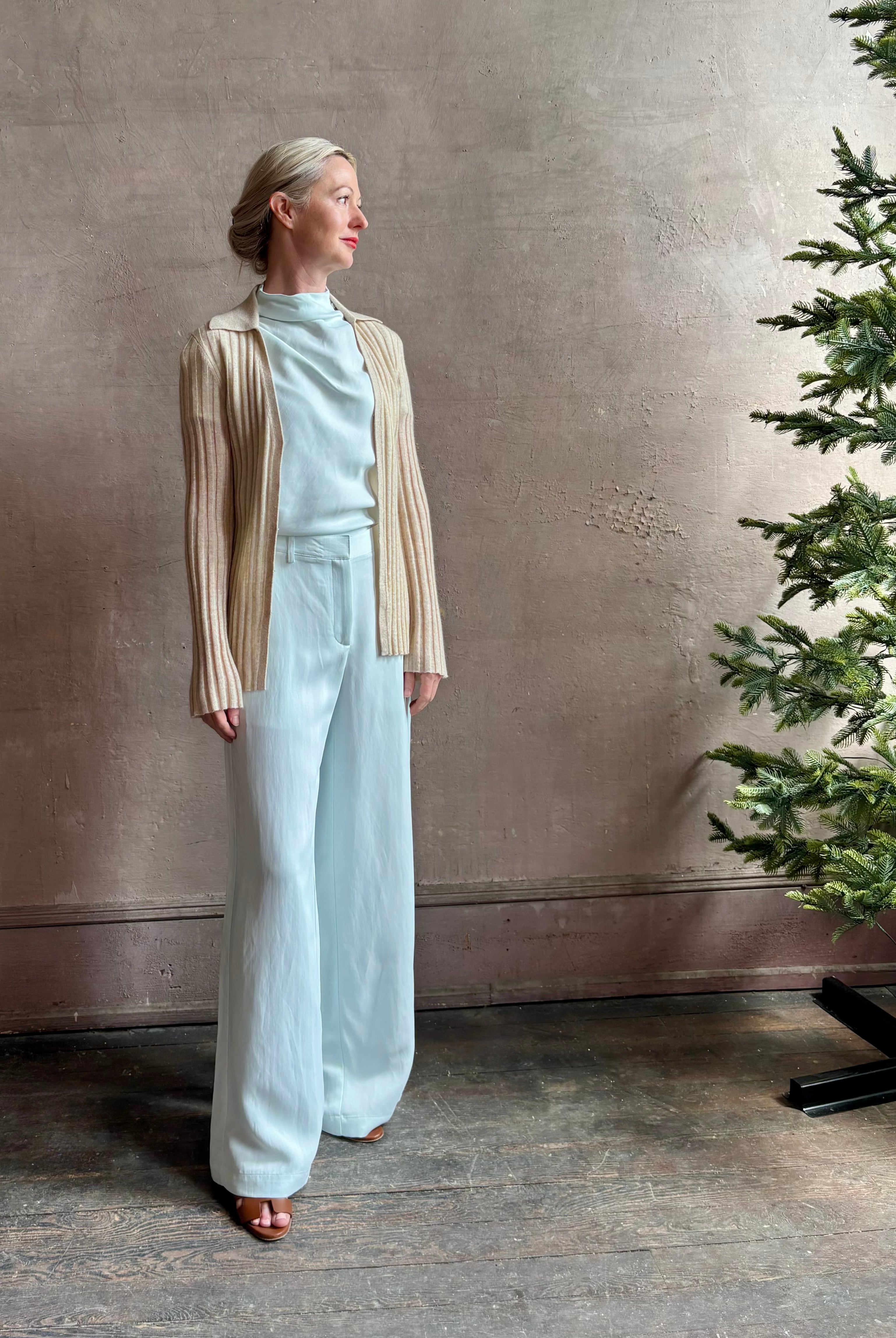 Image of mature woman wearing premium cashmere linen GUEST IN RESIDENCE Breezy Cardigan in Sandstone beige with long sleeves hook and eye front closure and ribbed texture