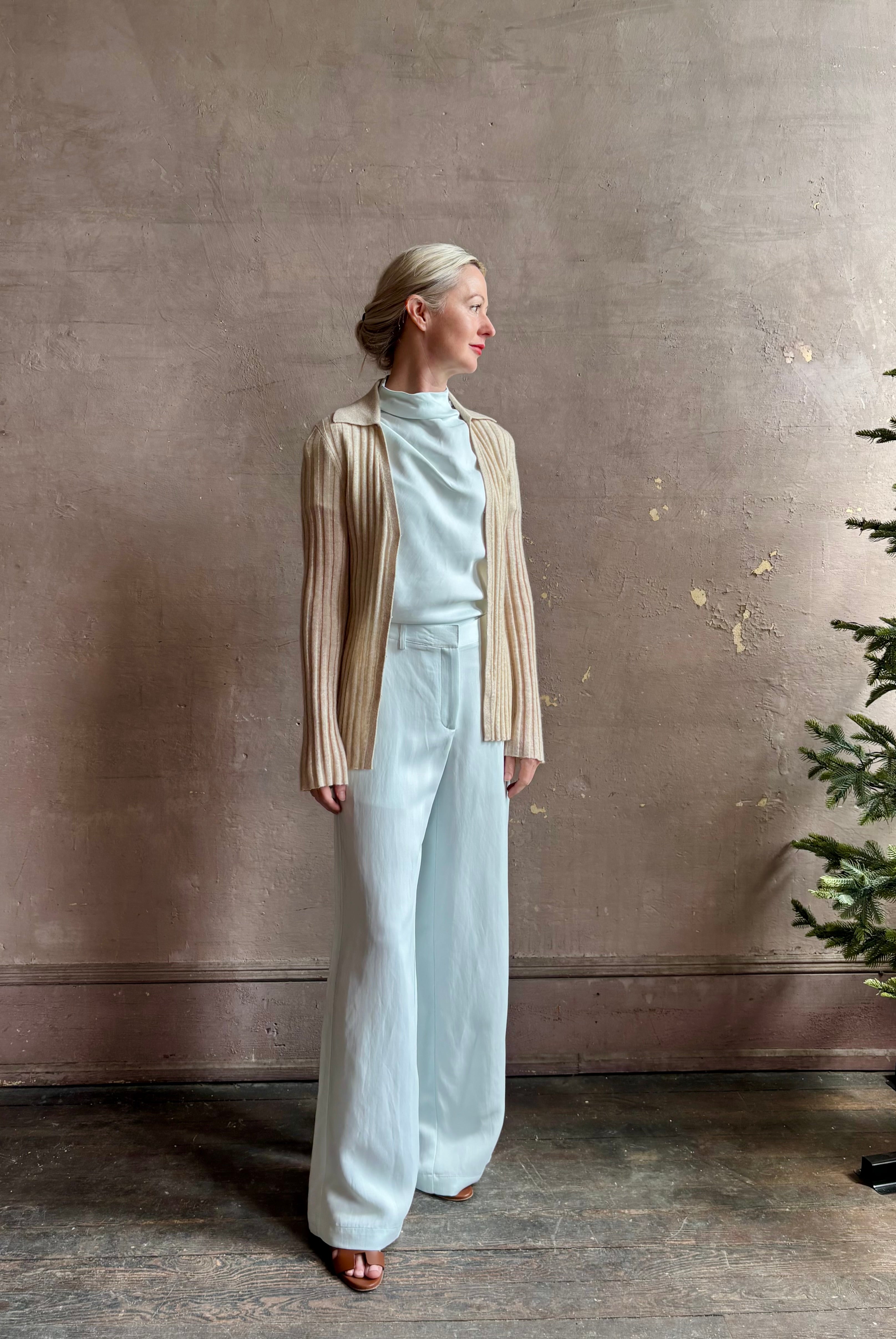 Image of mature woman wearing premium cashmere linen GUEST IN RESIDENCE Breezy Cardigan in Sandstone beige with long sleeves hook and eye front closure and ribbed texture