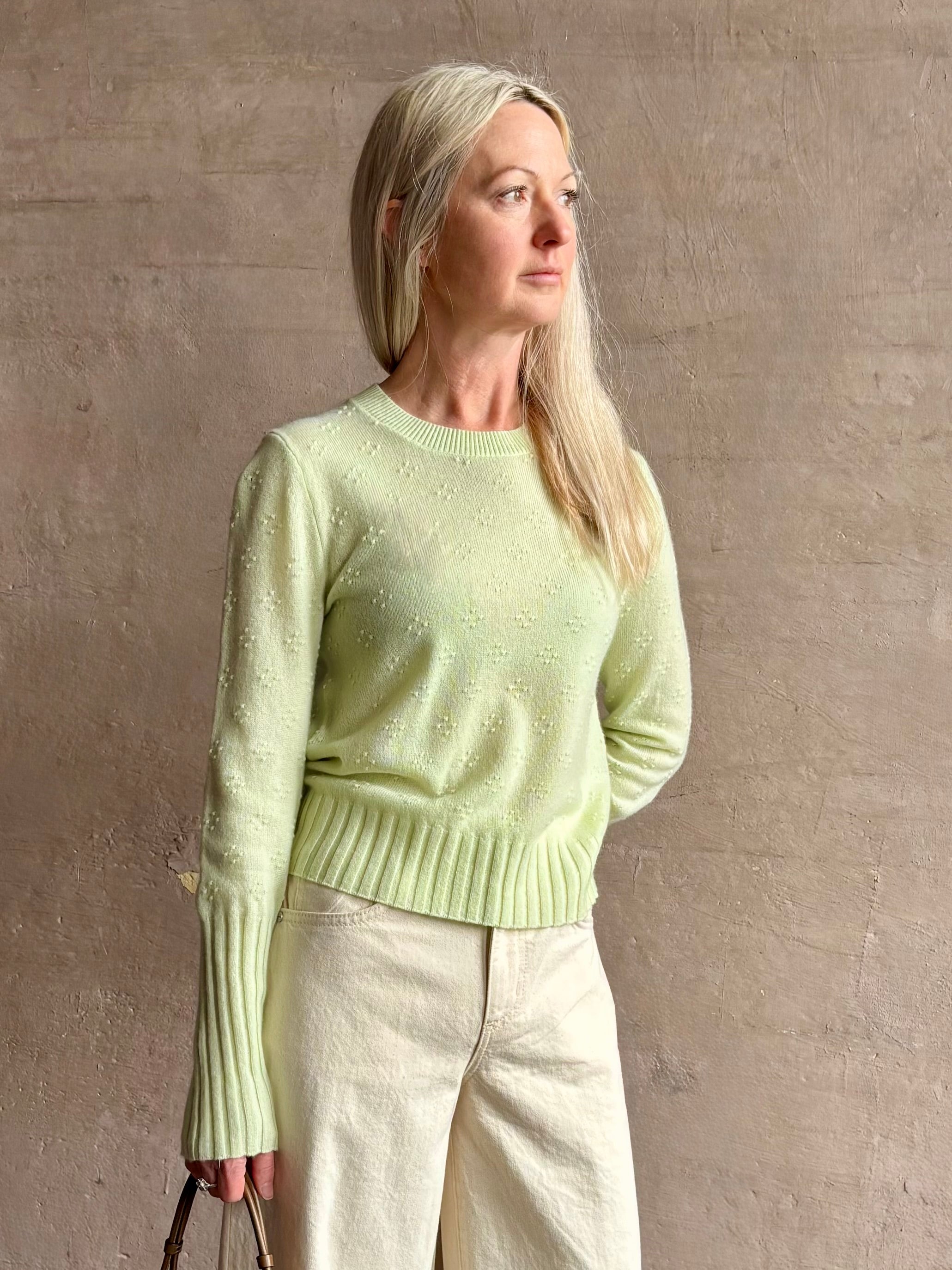 Image of woman wearing luxury cashmere crew neck sweater GUEST IN RESIDENCE Compass Shrunken Crew in Limewash Knitwear with long sleeves and dot detail throughout