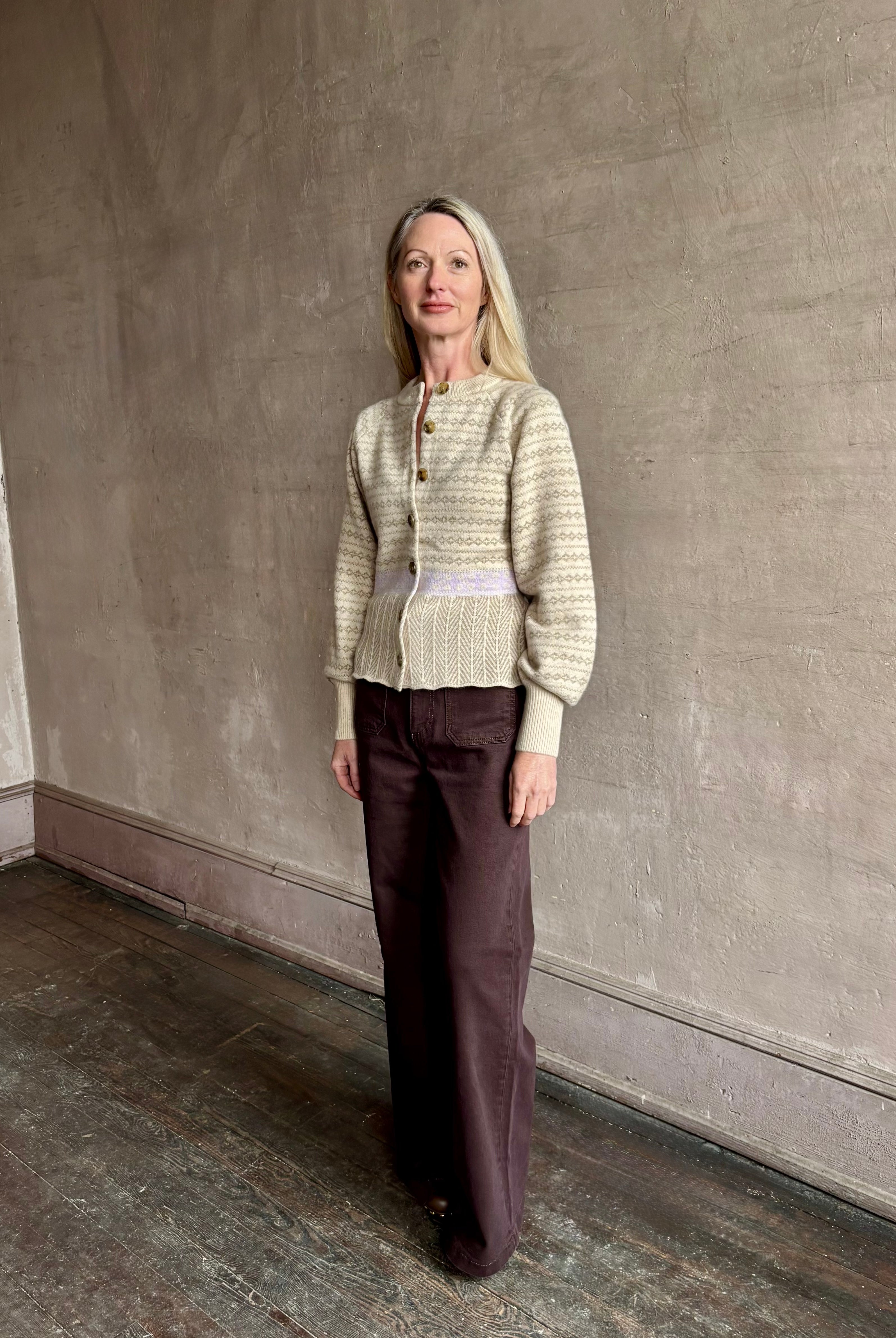 Image of mature woman wearing Guest in Residence Fairisle Cardigan in cream and beige pattern with a subtle lavender knit accent at waistline
