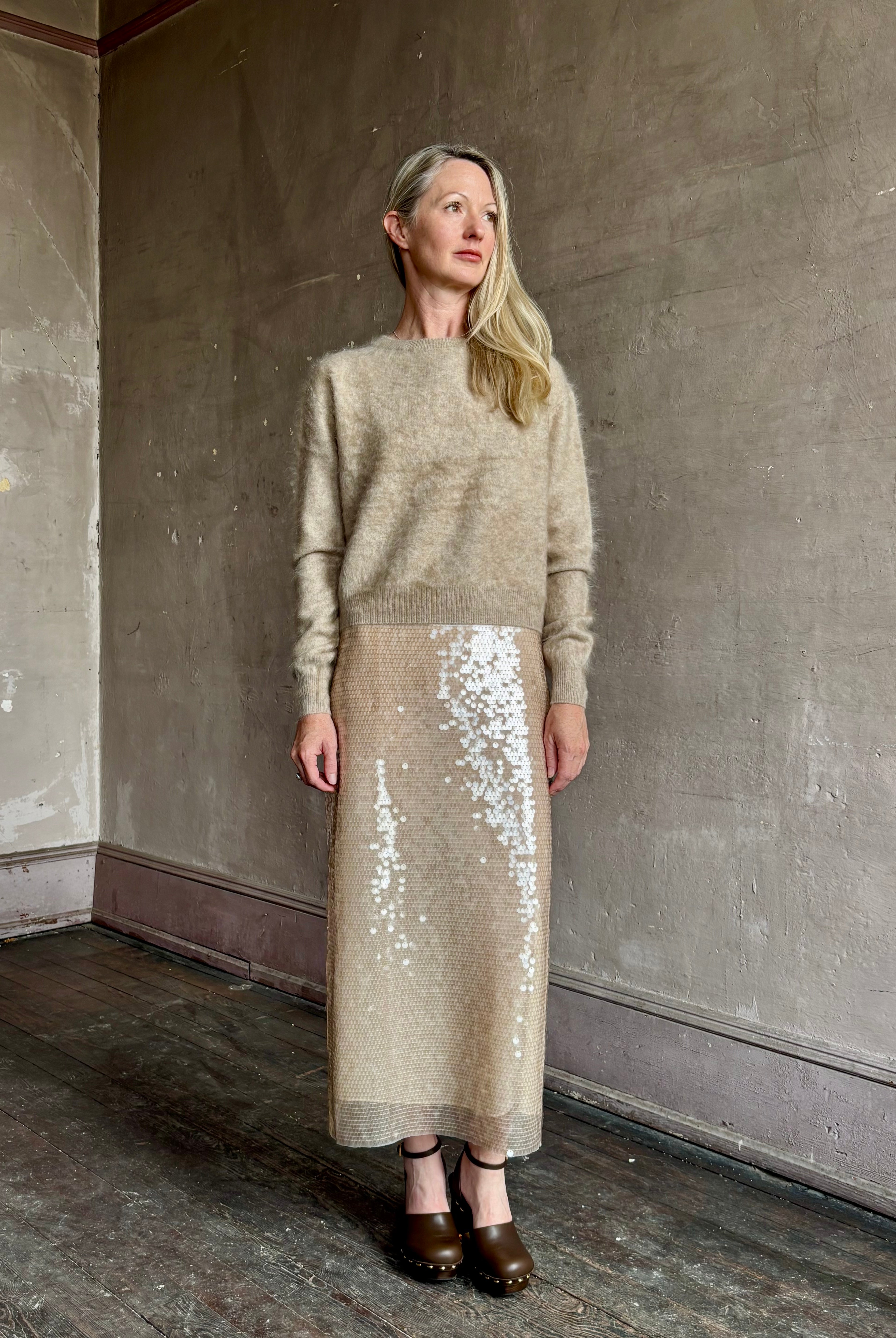 Image of mature model wearing New York luxury women's clothing brand Guest In Residence long-sleeve crew neck brushed cashmere beige sweater