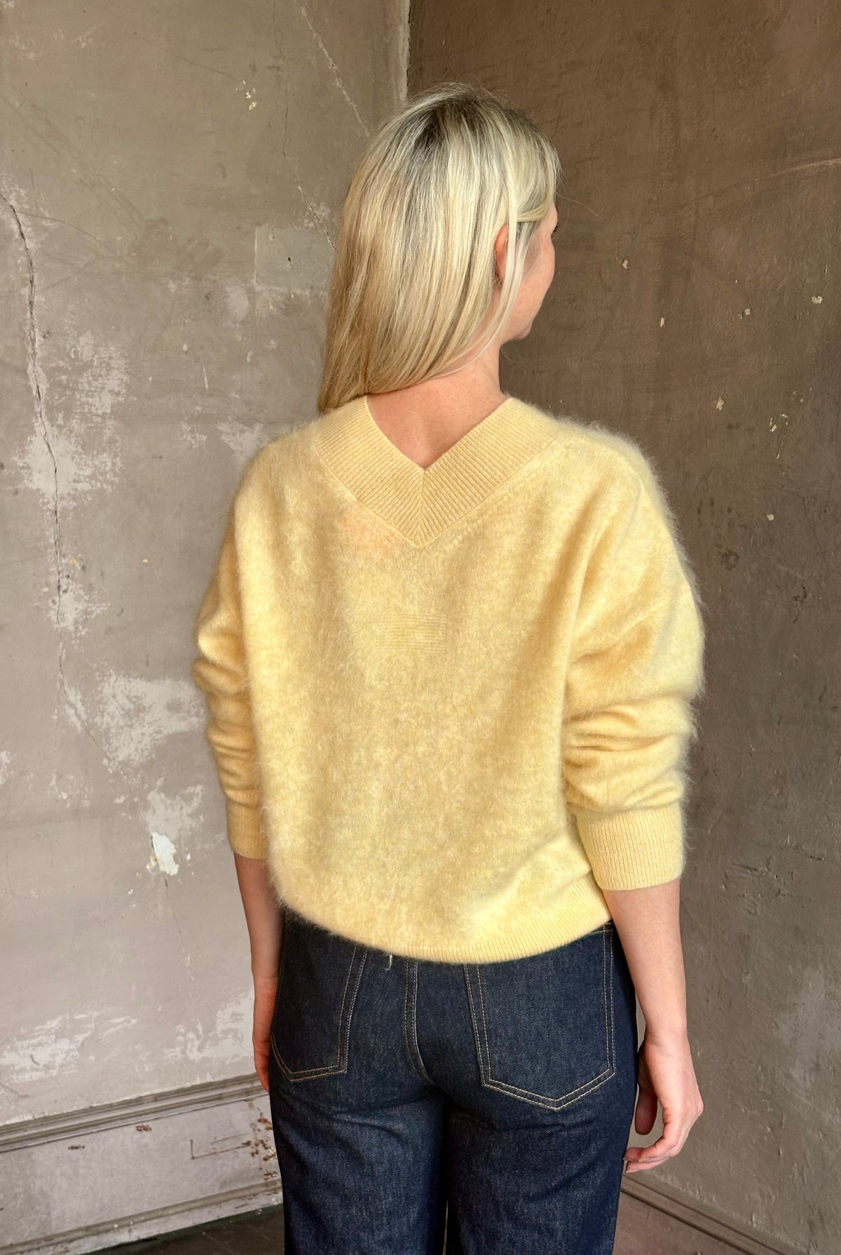 Mature woman wearing Guest in Residence Grizzly Double V Sweater in Butter brushed cashmere front-and-back V-necklines long sleeves