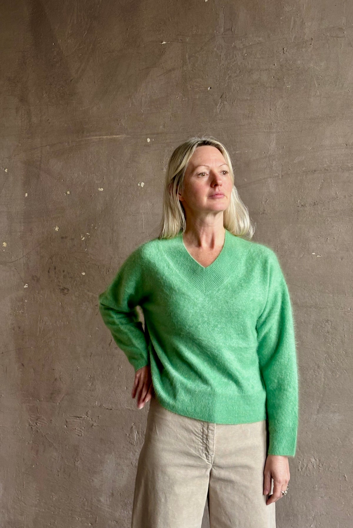 Mature woman wearing Guest in Residence Grizzly Double V Sweater Highland Green brushed cashmere with symmetrical front-and-back V-necklines