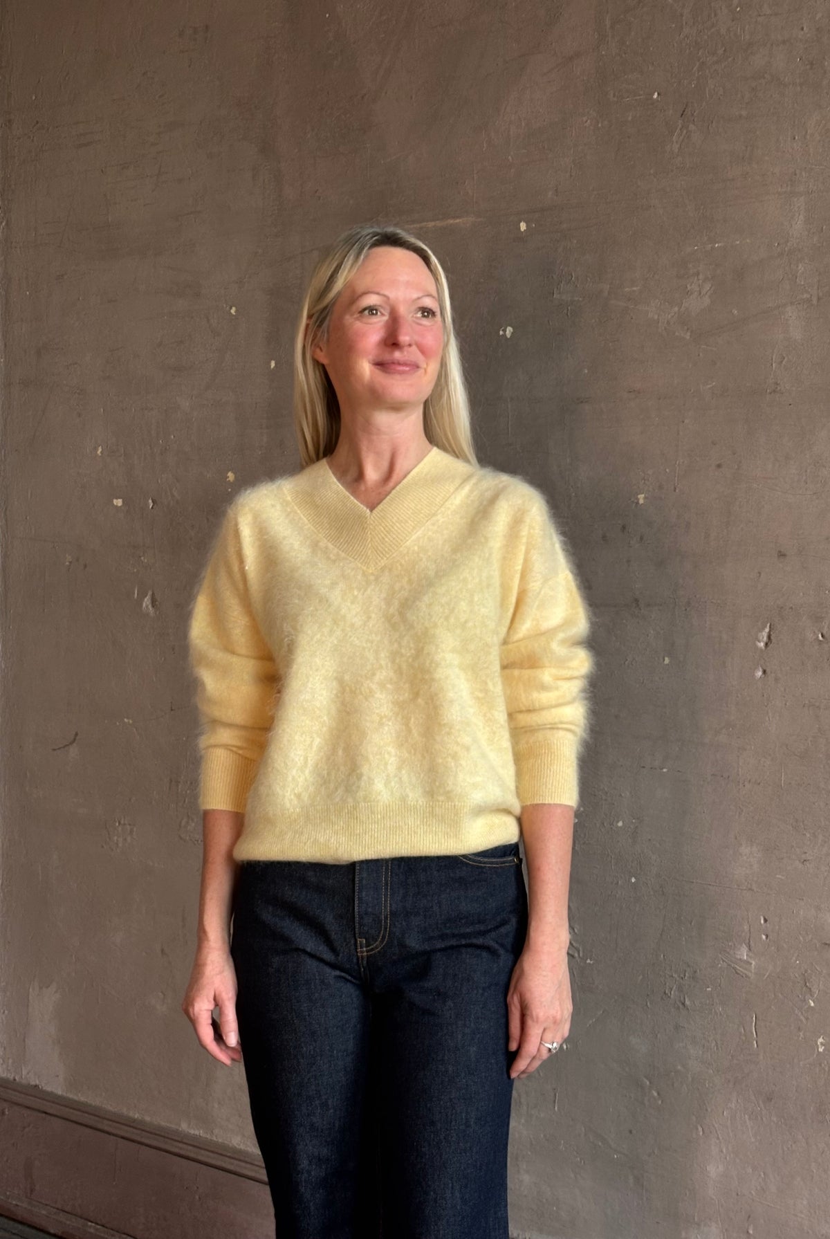 Mature woman wearing Guest in Residence Grizzly Double V Sweater in Butter brushed cashmere front-and-back V-necklines long sleeves