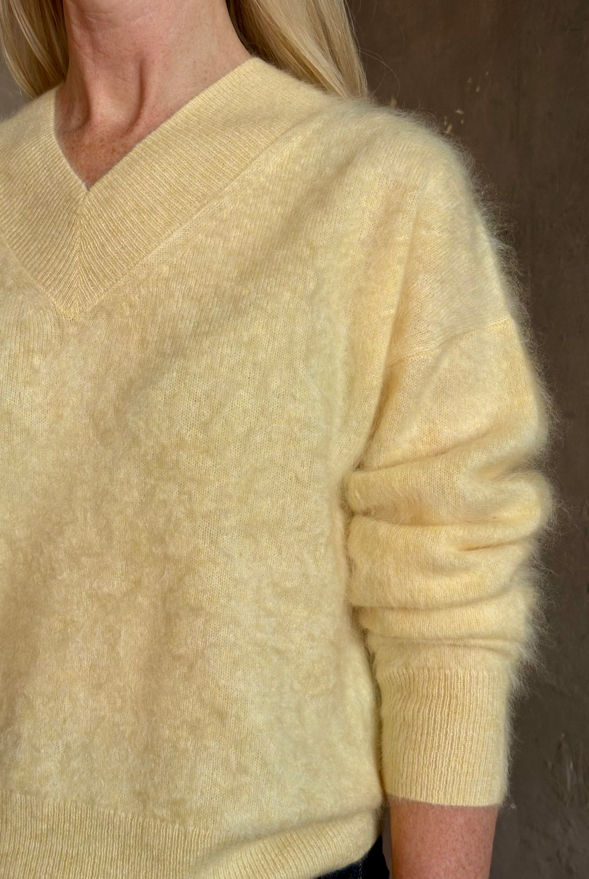 Mature woman wearing Guest in Residence Grizzly Double V Sweater in Butter brushed cashmere front-and-back V-necklines long sleeves