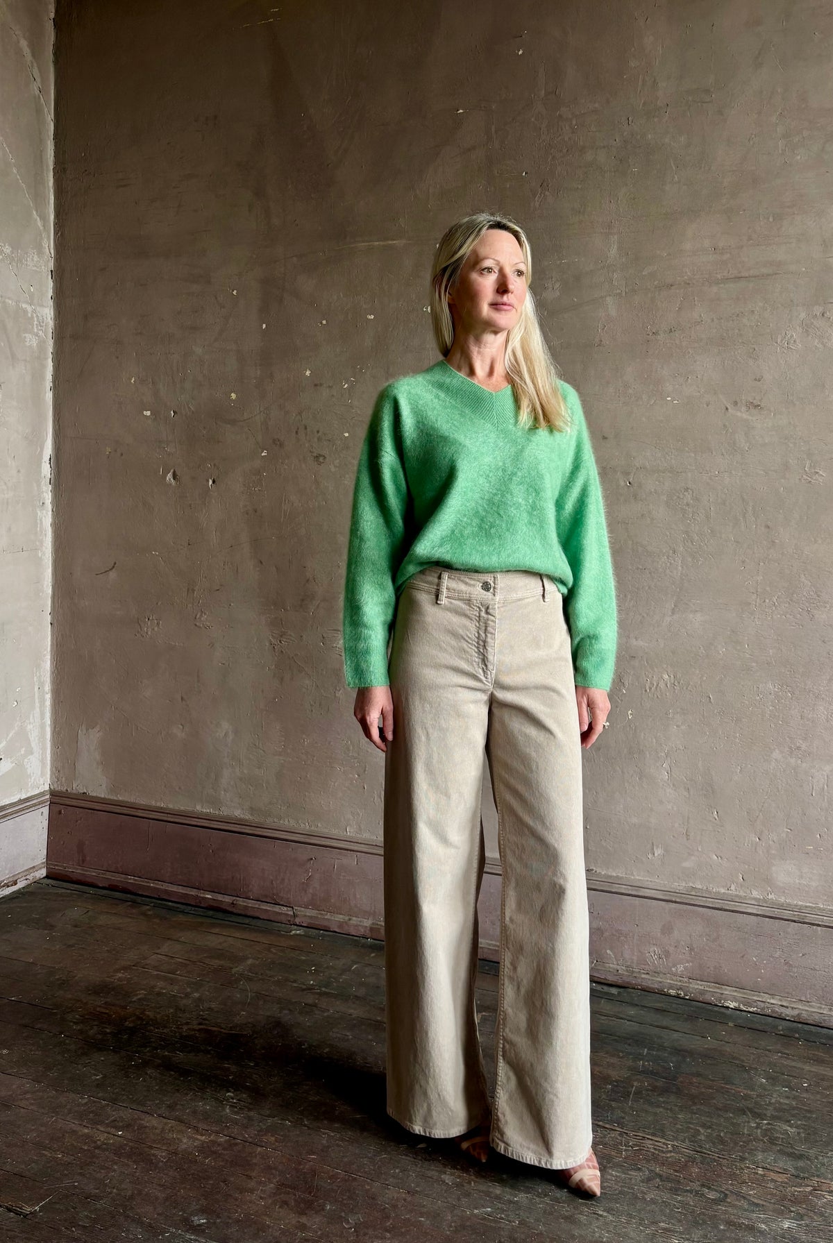Mature woman wearing Guest in Residence Grizzly Double V Sweater Highland Green brushed cashmere with symmetrical front-and-back V-necklines
