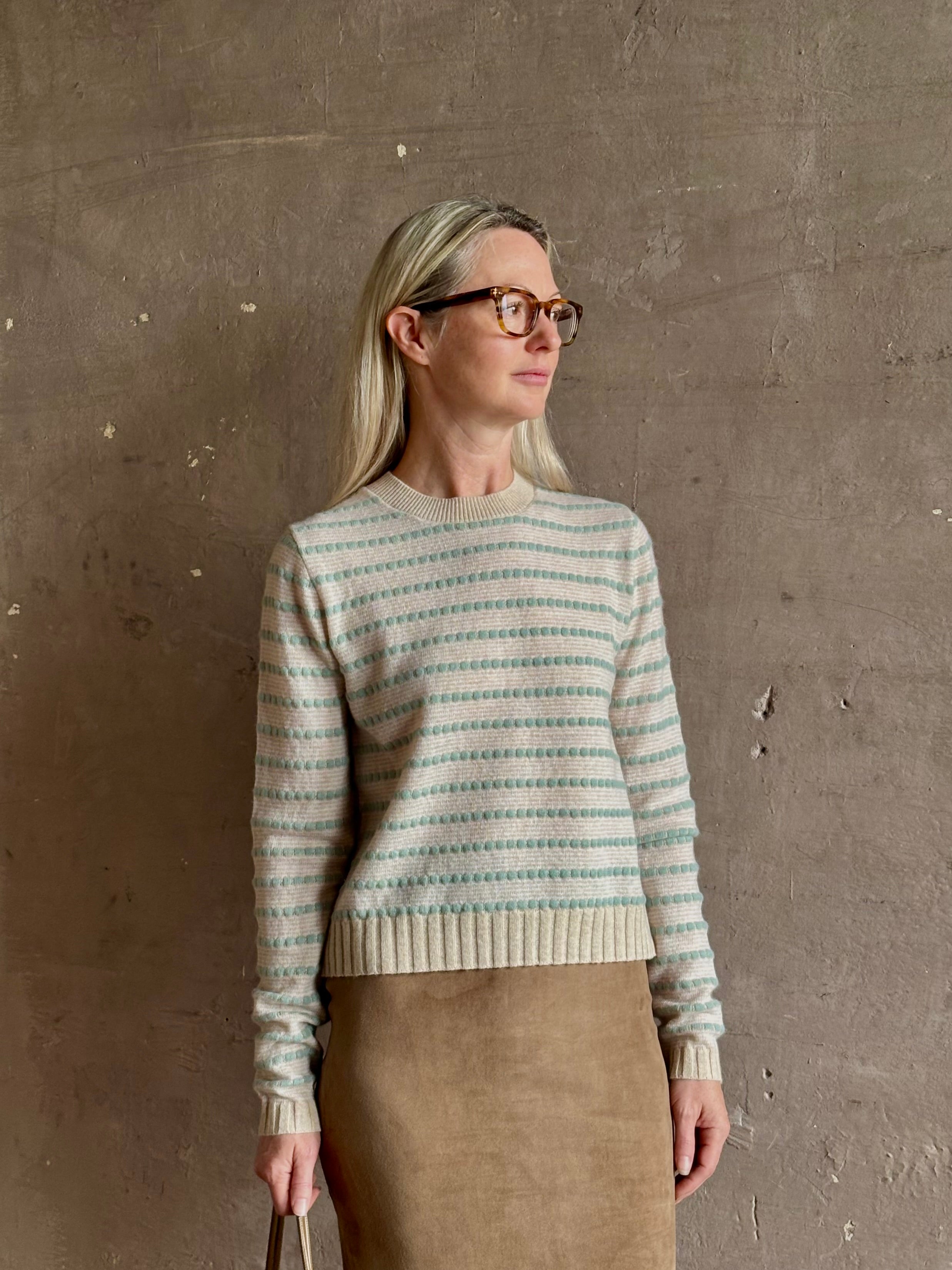 Mature woman wearing Guest in Residence Pebble cream and sage stripe shrunken crew long sleeve cashmere sweater