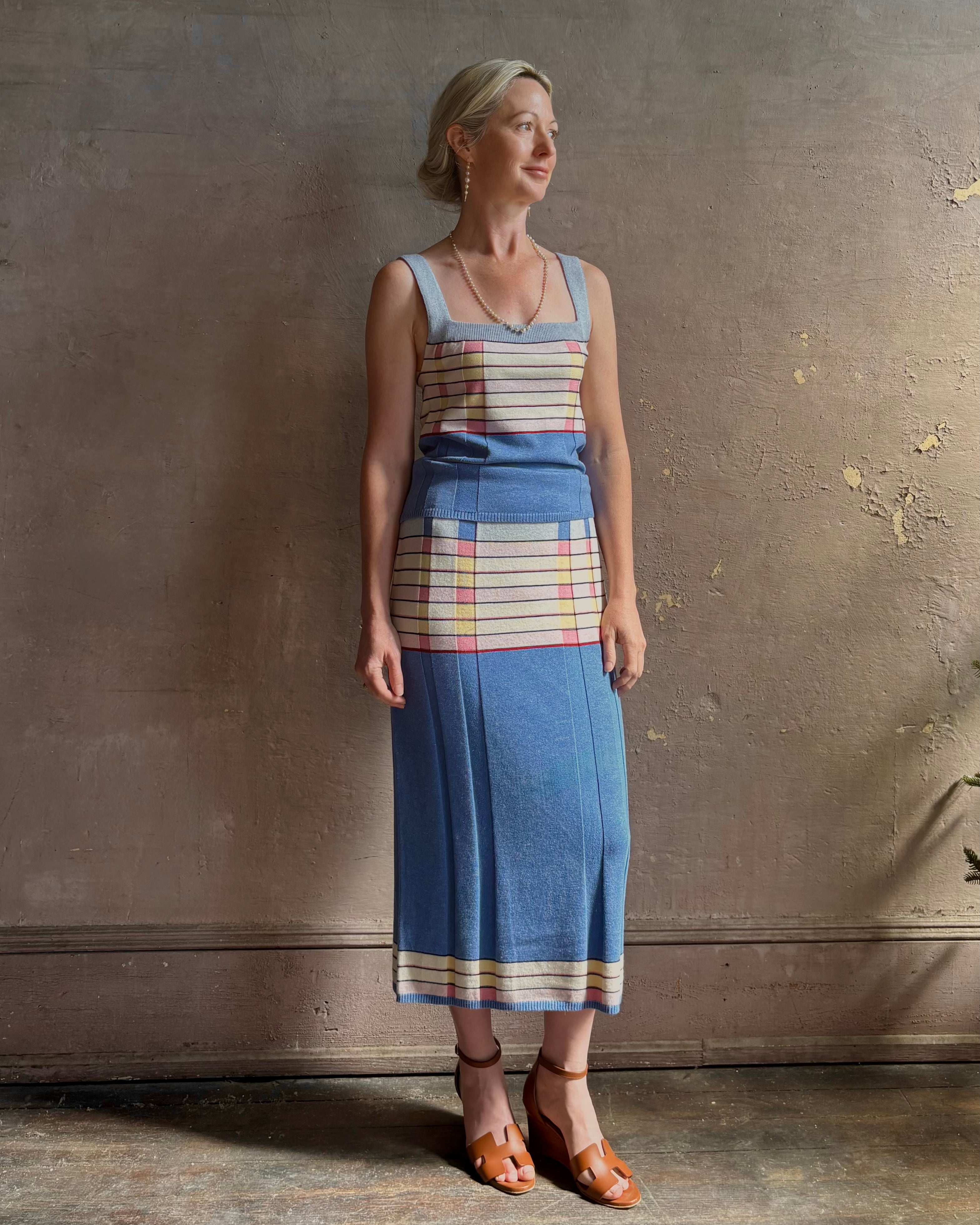 Mature woman wearing Plaited Rib knit pencil Skirt from Guest in Residence rendered in delft blue and crafted from a luxurious blend of silk, linen, nylon, and elastane with wide rib texture down front and back with pink and yellow horizontal stripes at hips and bottom edge