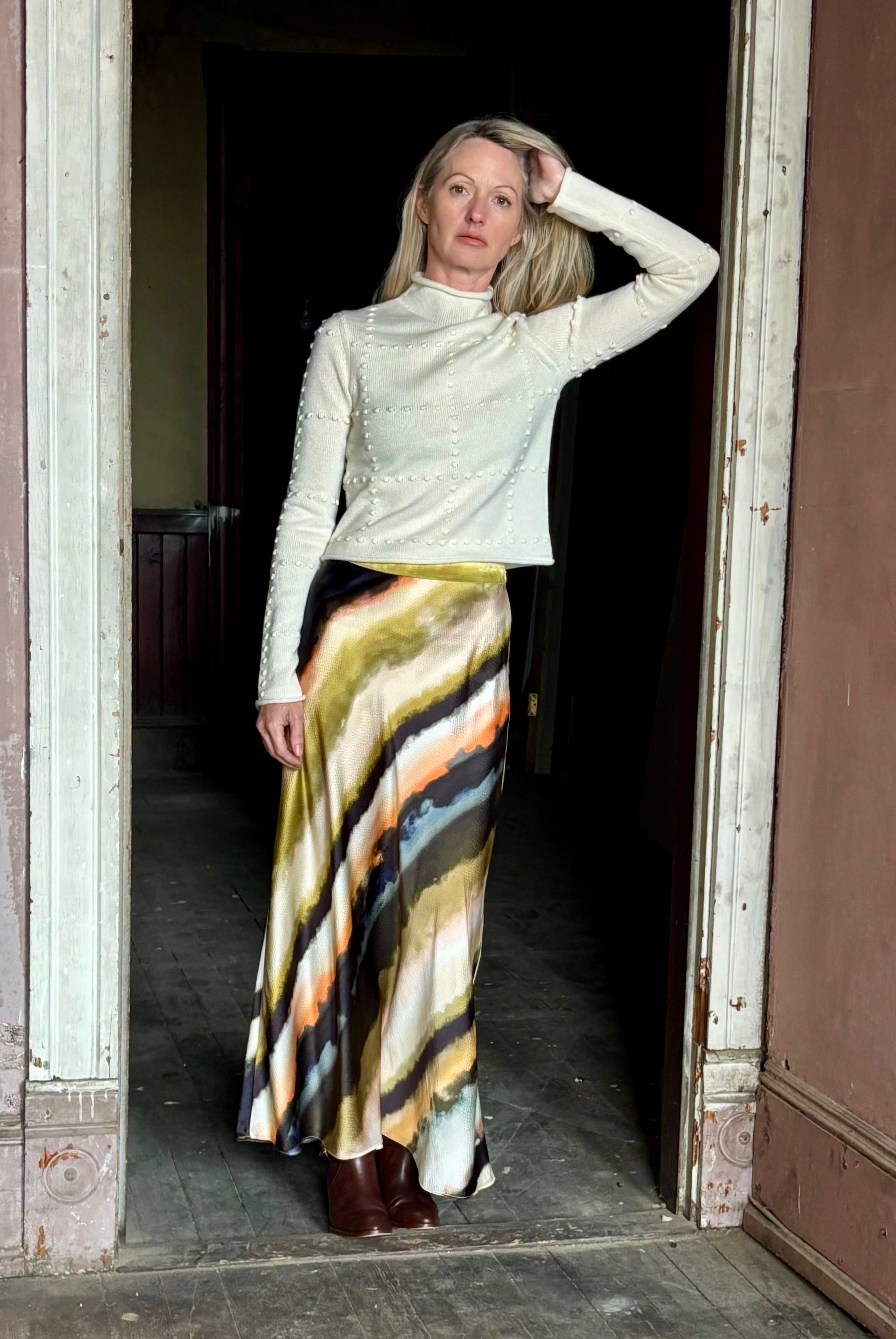 Image of mature woman wearing a cream cashmere blend sweater from NYC based celebrity brand Guest in Residence with geometric texture pattern