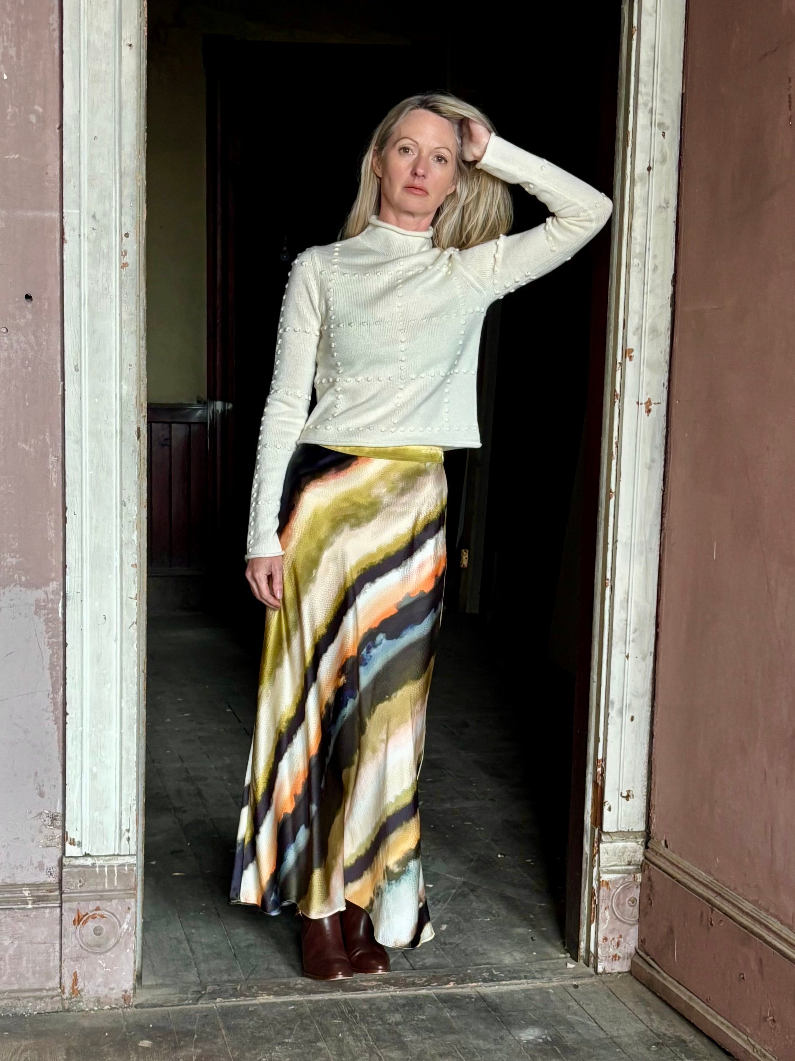 Image of mature woman wearing a cream cashmere blend sweater from NYC based celebrity brand Guest in Residence with geometric texture pattern