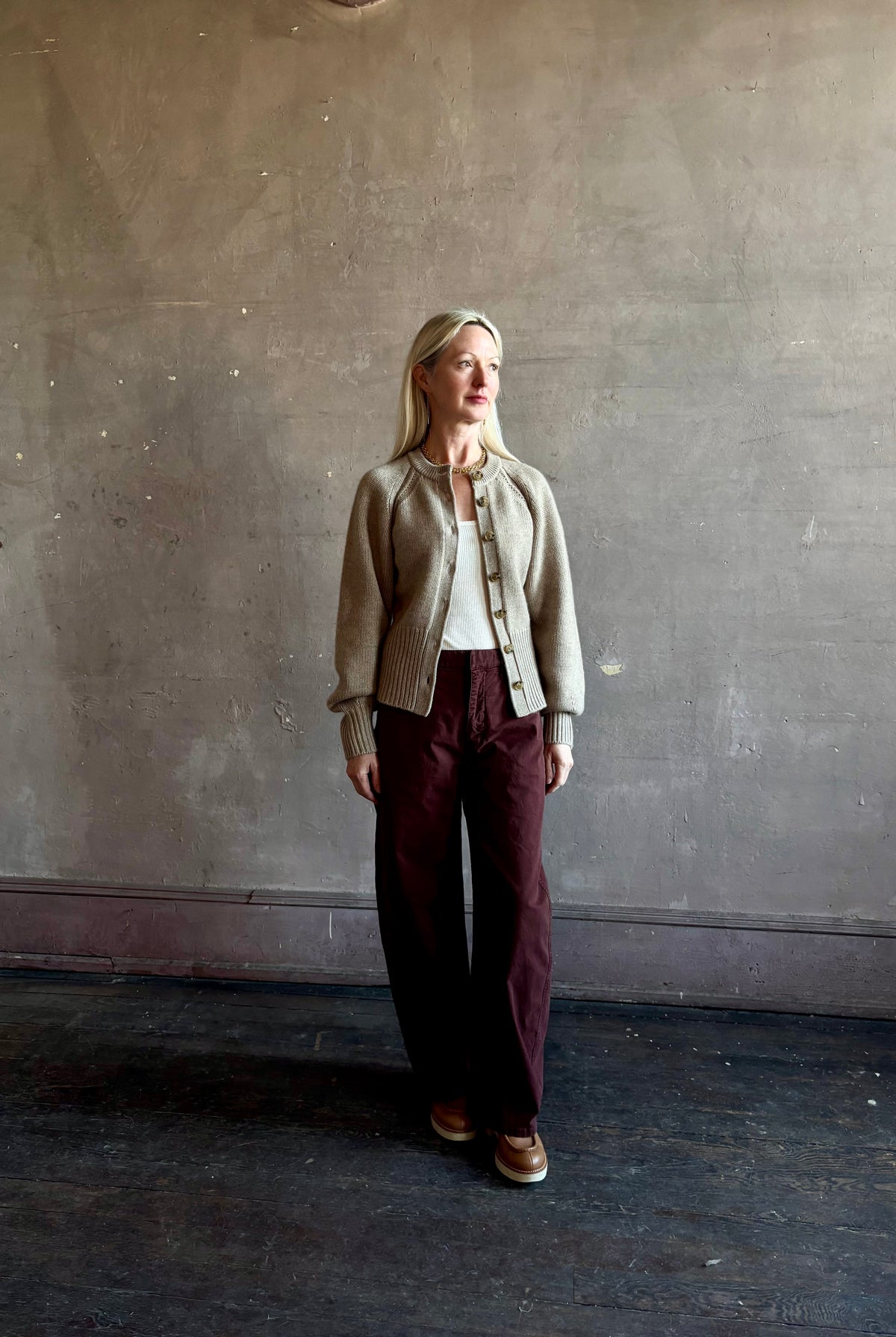 Mature woman wearing Guest in Residence Sculpted Cardigan in Taupe medium gauge cashmere raglan sleeves button front fitted waist softly structured