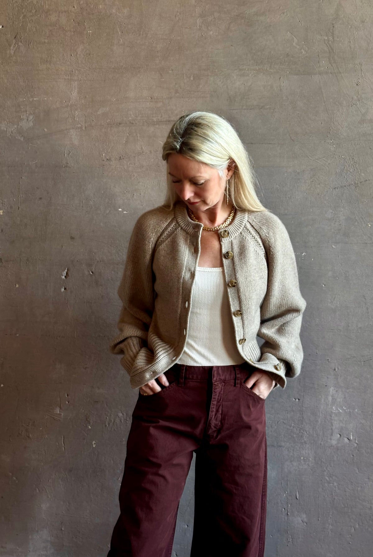 Mature woman wearing Guest in Residence Sculpted Cardigan in Taupe medium gauge cashmere raglan sleeves button front fitted waist softly structured