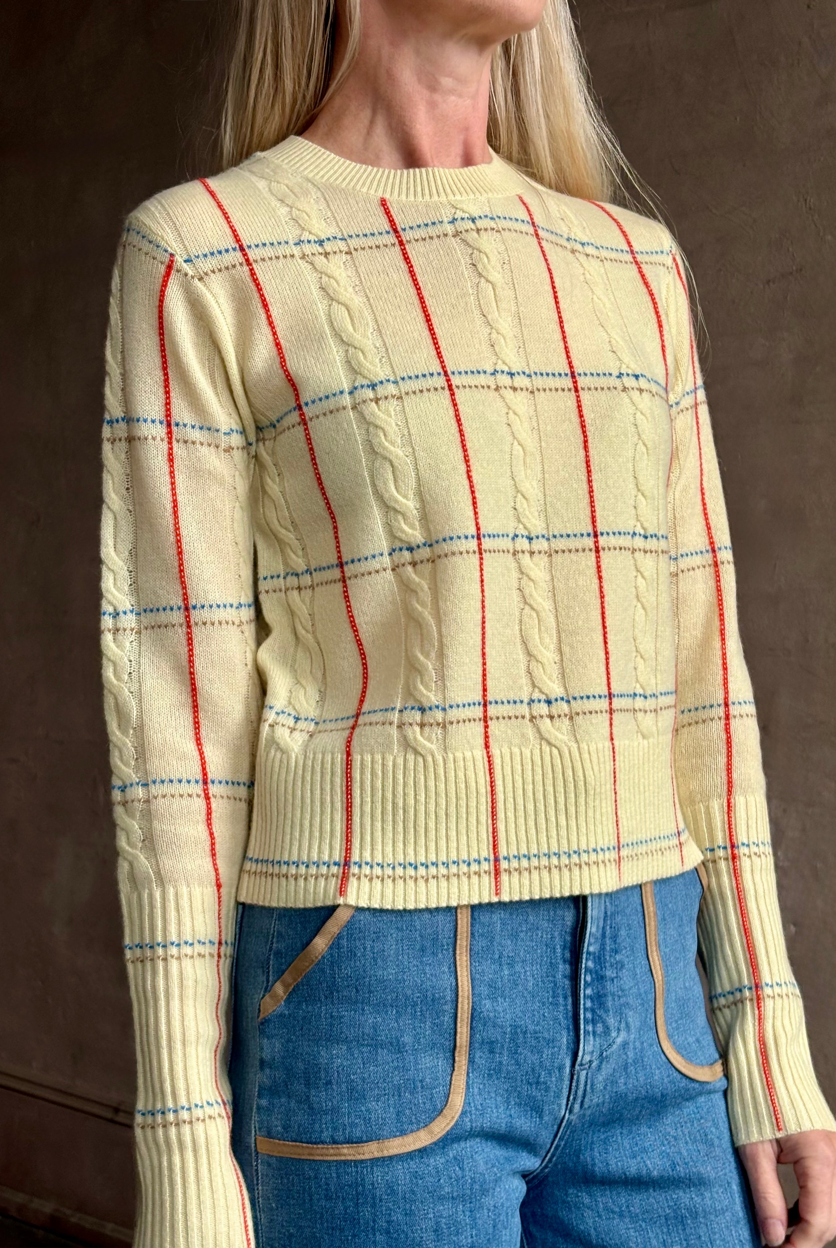 Image of woman wearing designer Guest in Residence yellow combo sweater with cable texture and subtle red, blue and beige plaid stripes pattern