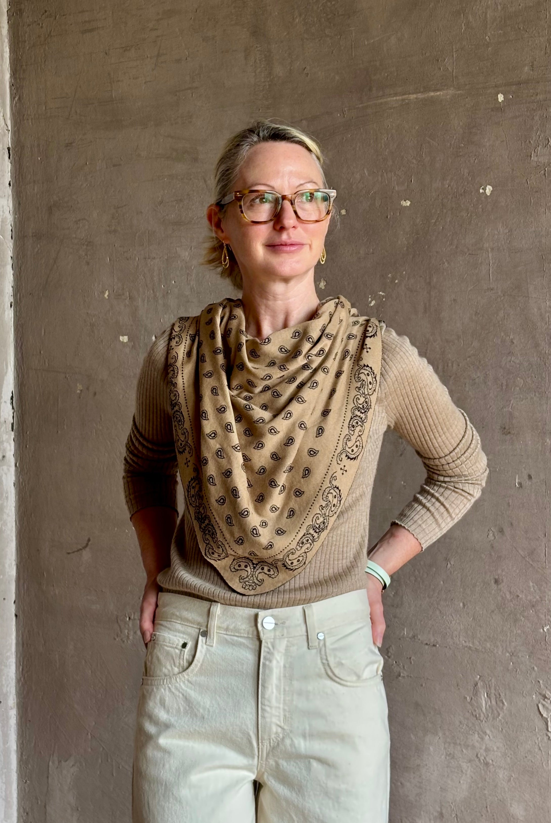 Mature woman wearing Guest in Residence The Wild Rag camel brown patterned bandana triangle reversible scarf