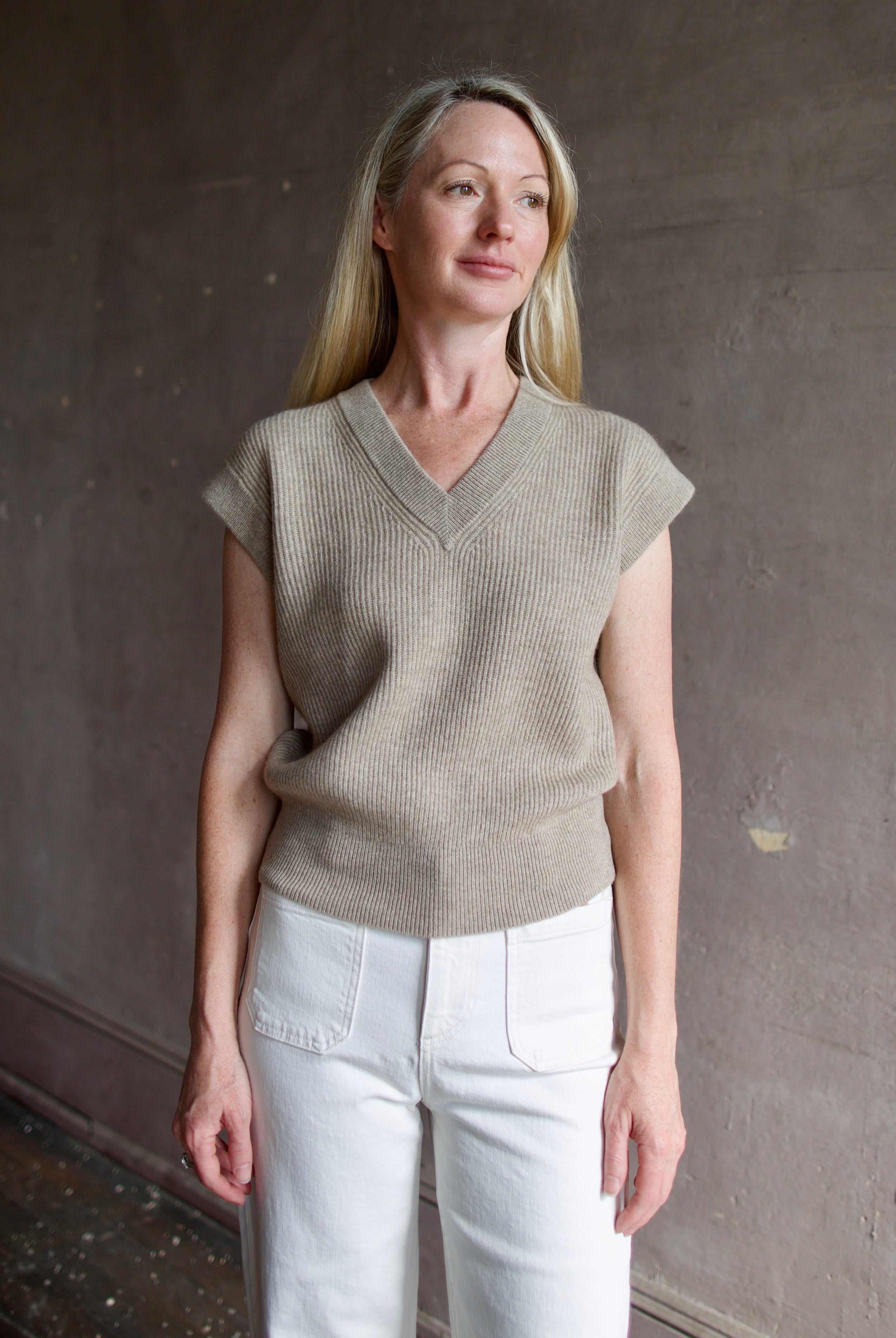 Mature model wearing premium designer Guest in Residence taupe Rib Vest with v-neck and luxury Mongolian cashmere fabrication