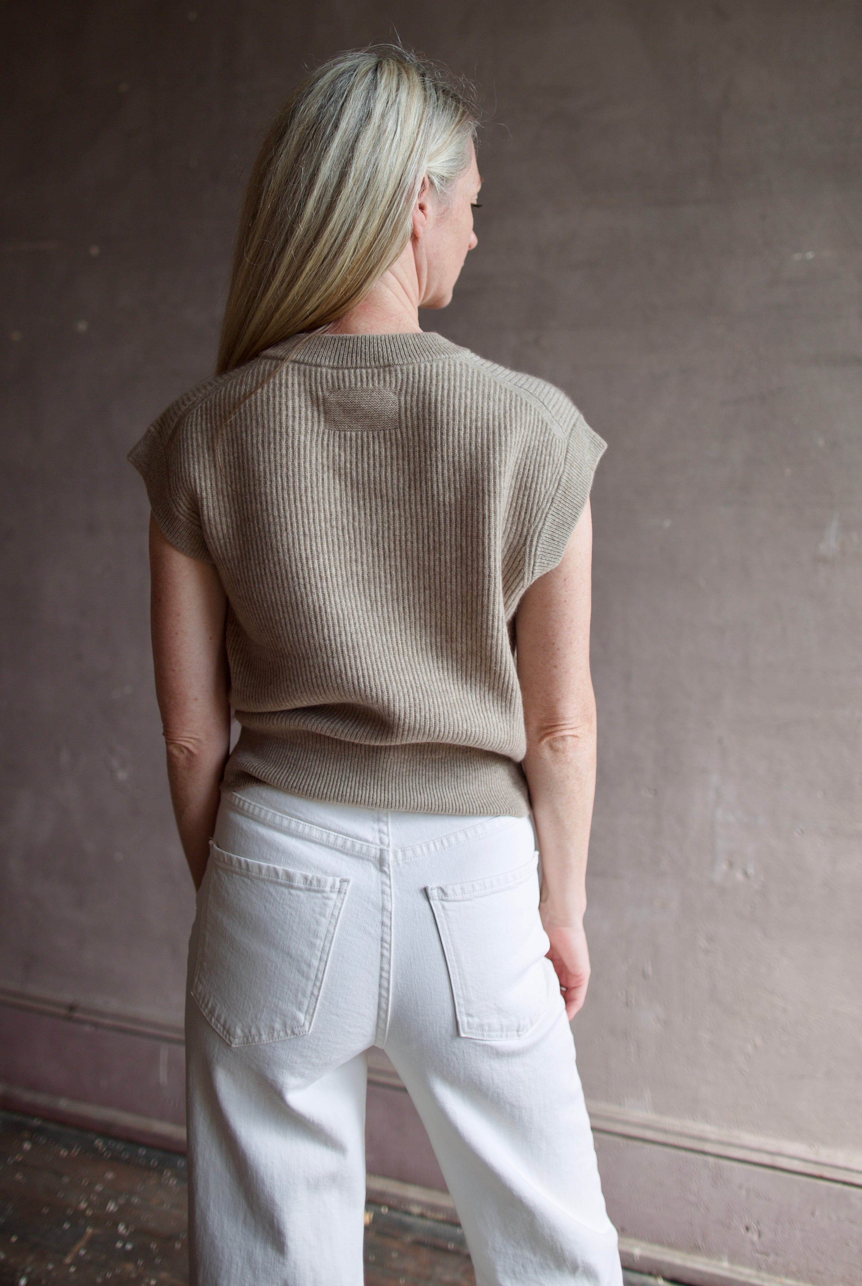 Mature model wearing premium designer Guest in Residence taupe Rib Vest with v-neck and luxury Mongolian cashmere fabrication