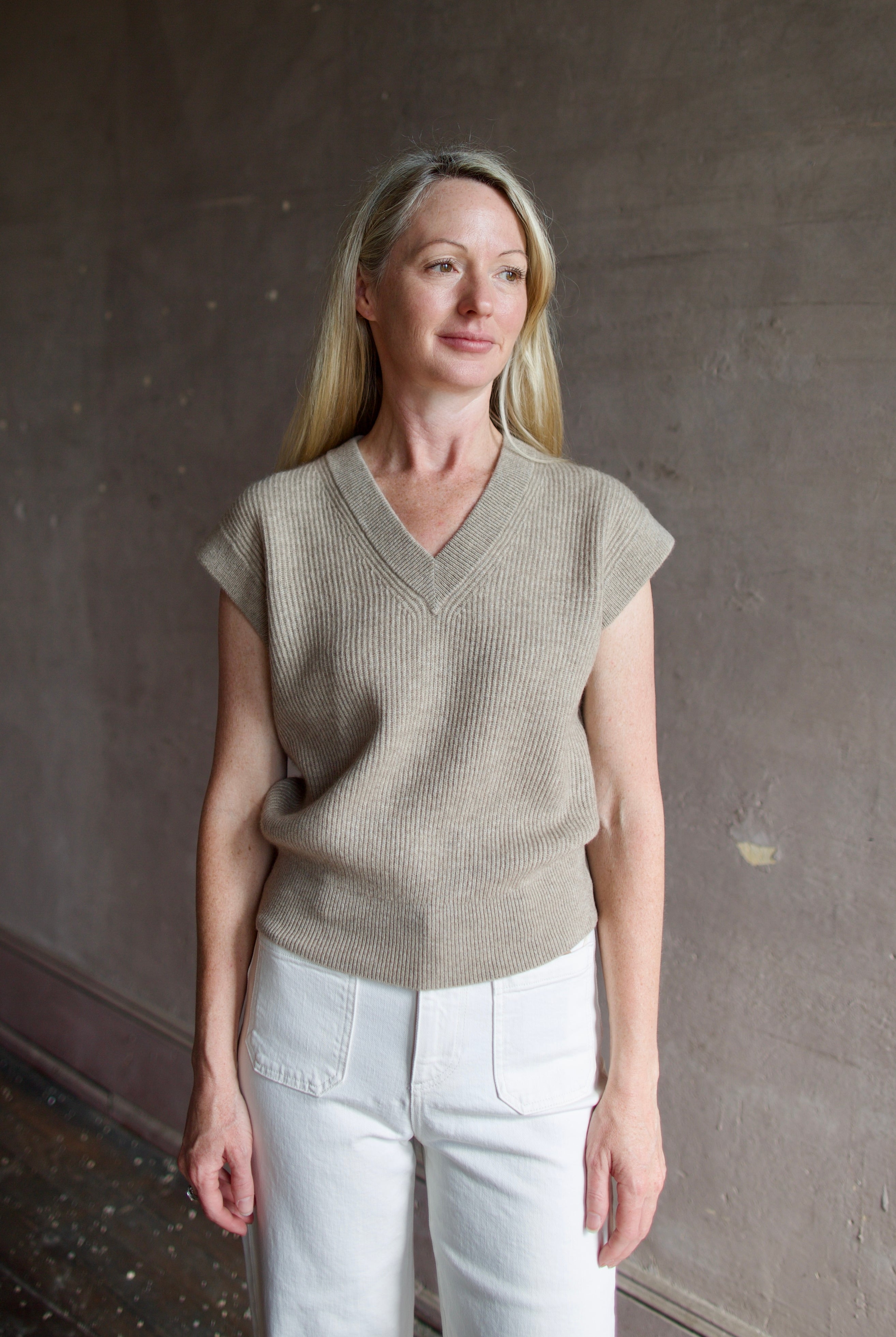 Mature model wearing premium designer Guest in Residence taupe Rib Vest with v-neck and luxury Mongolian cashmere fabrication