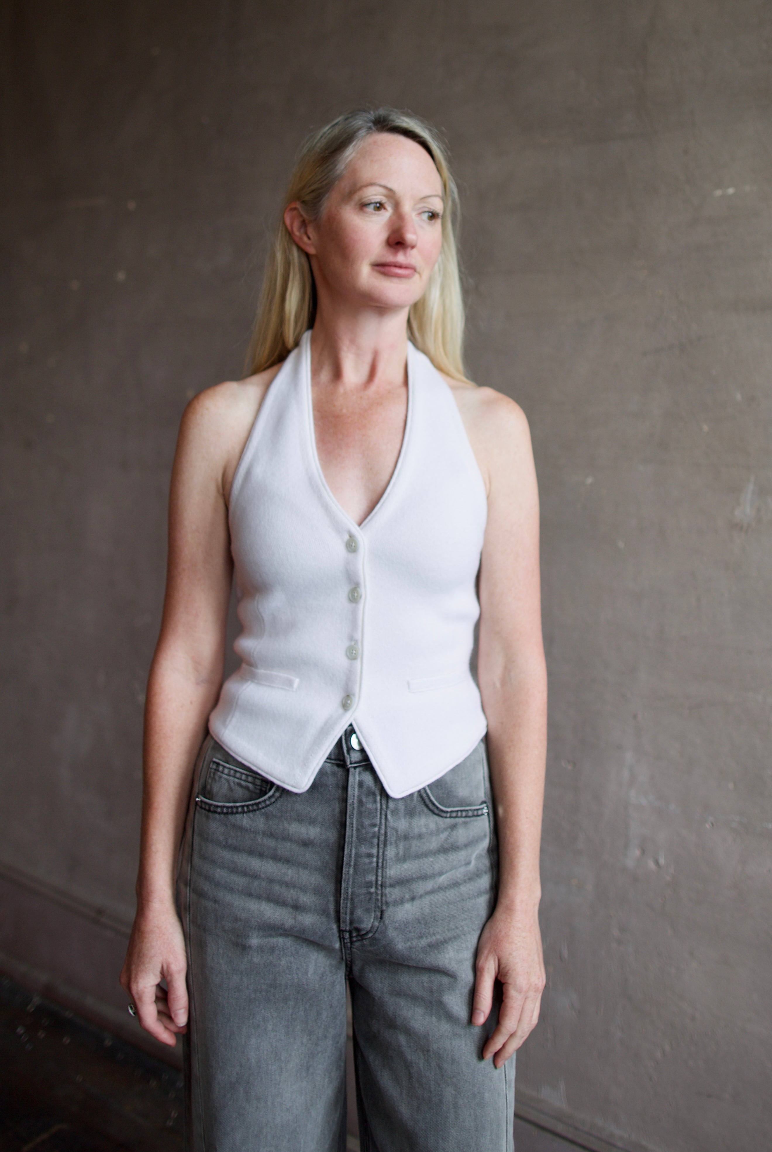 Image of model wearing a white premium cashmere halter top vest with expert tailoring from Guest In Residence