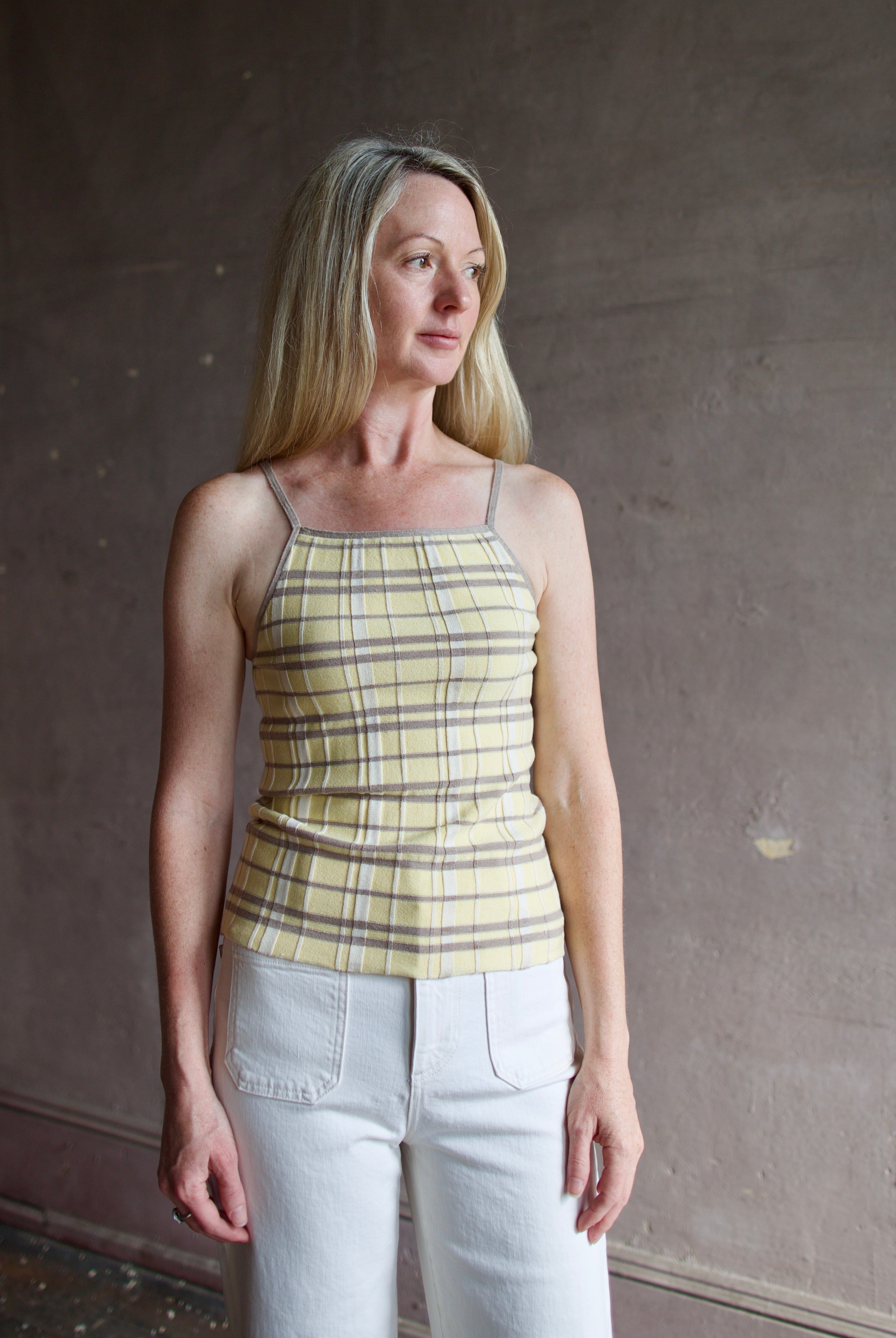 Model wearing premium designer Guest in Residence Plaid Tank top in butter yellow with taupe and white plaid pattern in lightweight silk linen blend