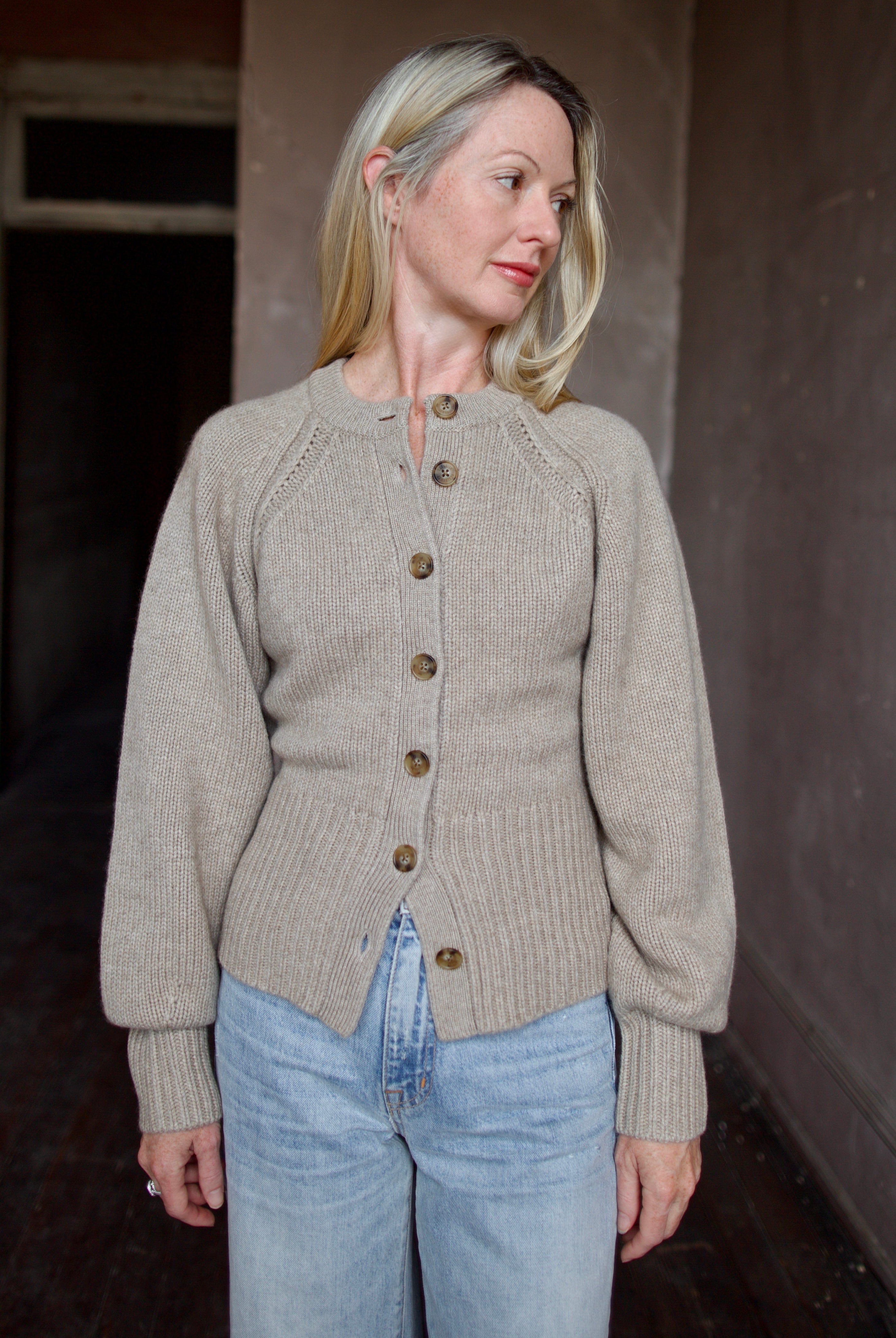 Model wearing a beige Guest in Residence cashmere cardigan with Slvrlake denim