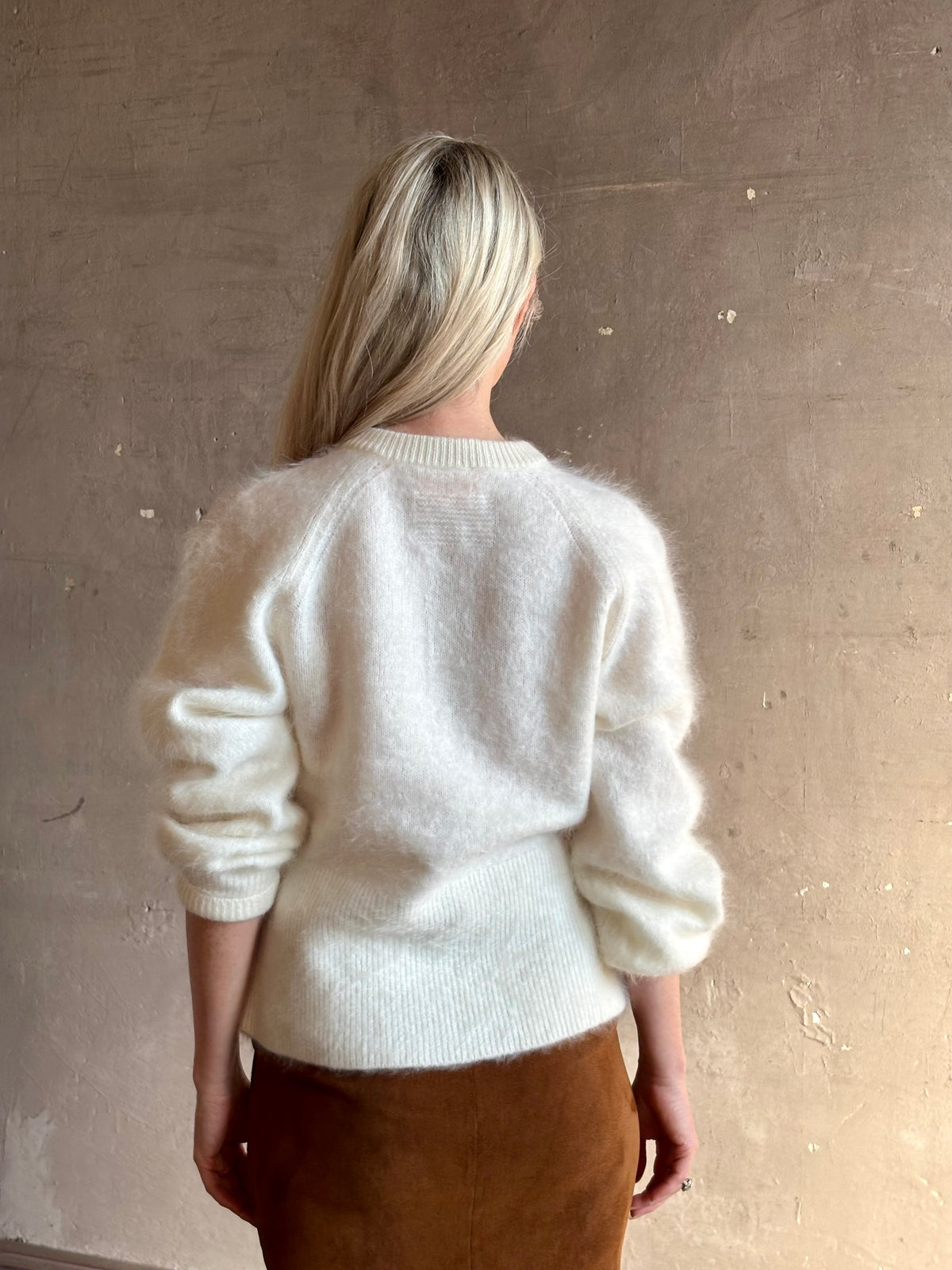 Back image of a Mature woman wearing Guest in Residence’s Grizzly Sculptured Cream brushed cashmere cardigan with crew neck fitted ribbed waistband and henley style long sleeves