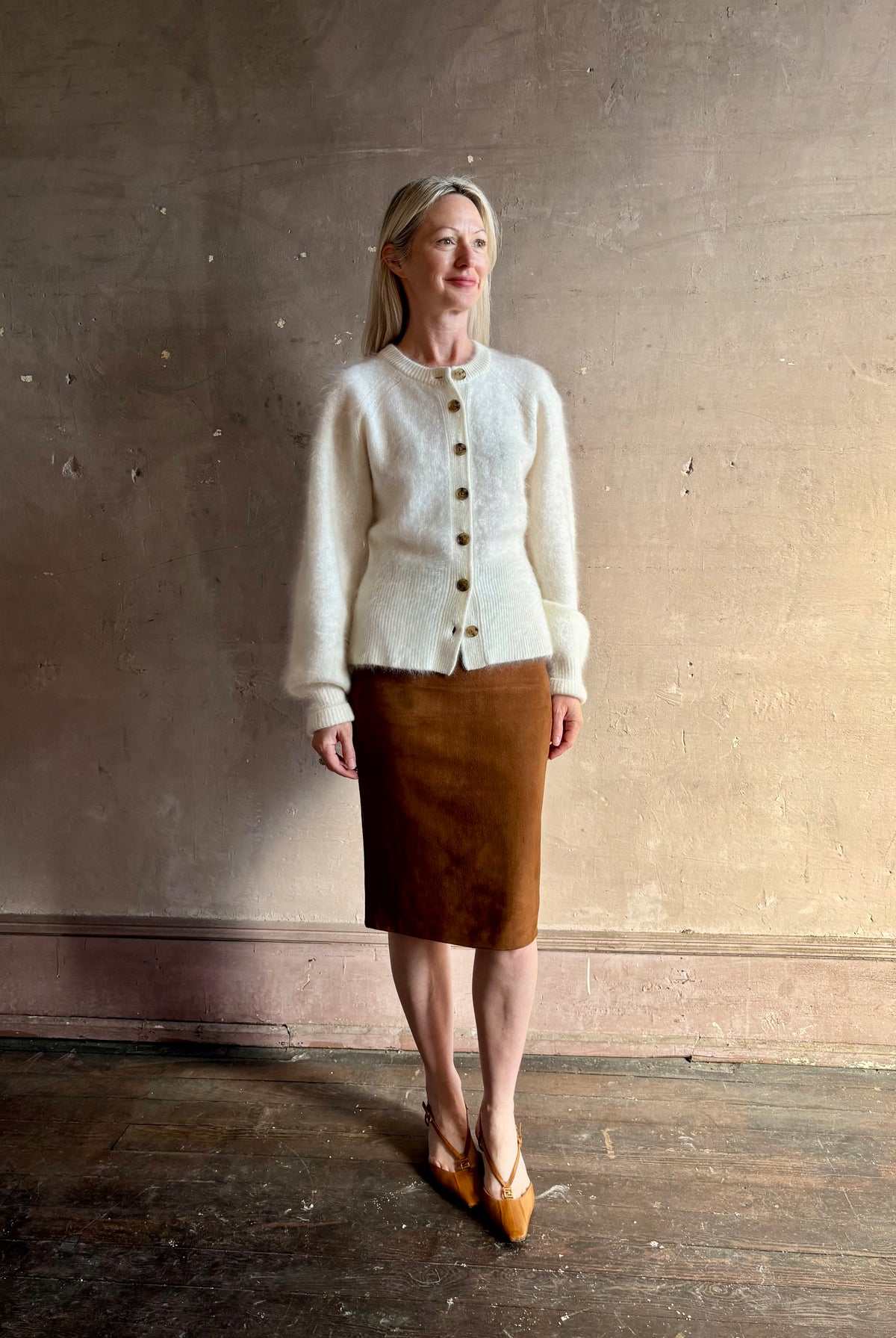 Mature woman wearing Guest in Residence’s Grizzly Sculptured Cream brushed cashmere button front cardigan ribbed trims soft luxury layer