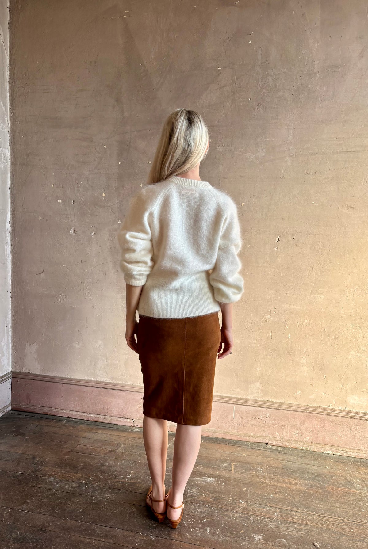 back image of Mature woman wearing a cream-colored brushed cashmere cardigan by Gigi Hadid Guest in Residence with feminine sihlouette and fitted waistband