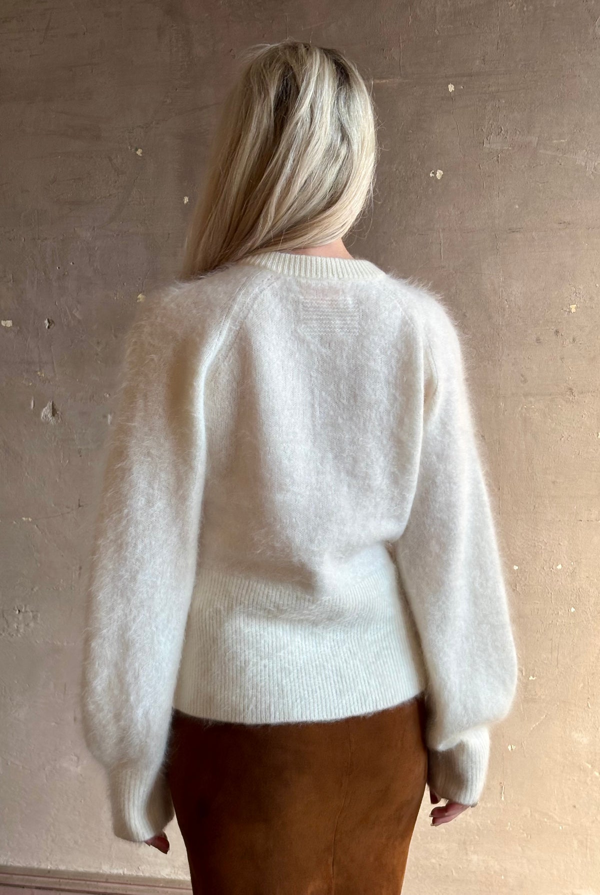 Close up rear image of Guest in Residence Grizzly sculpted cardigan in brushed cashmere with feminine sihlouette and fitted ribbed waistband and henley style long sleeves