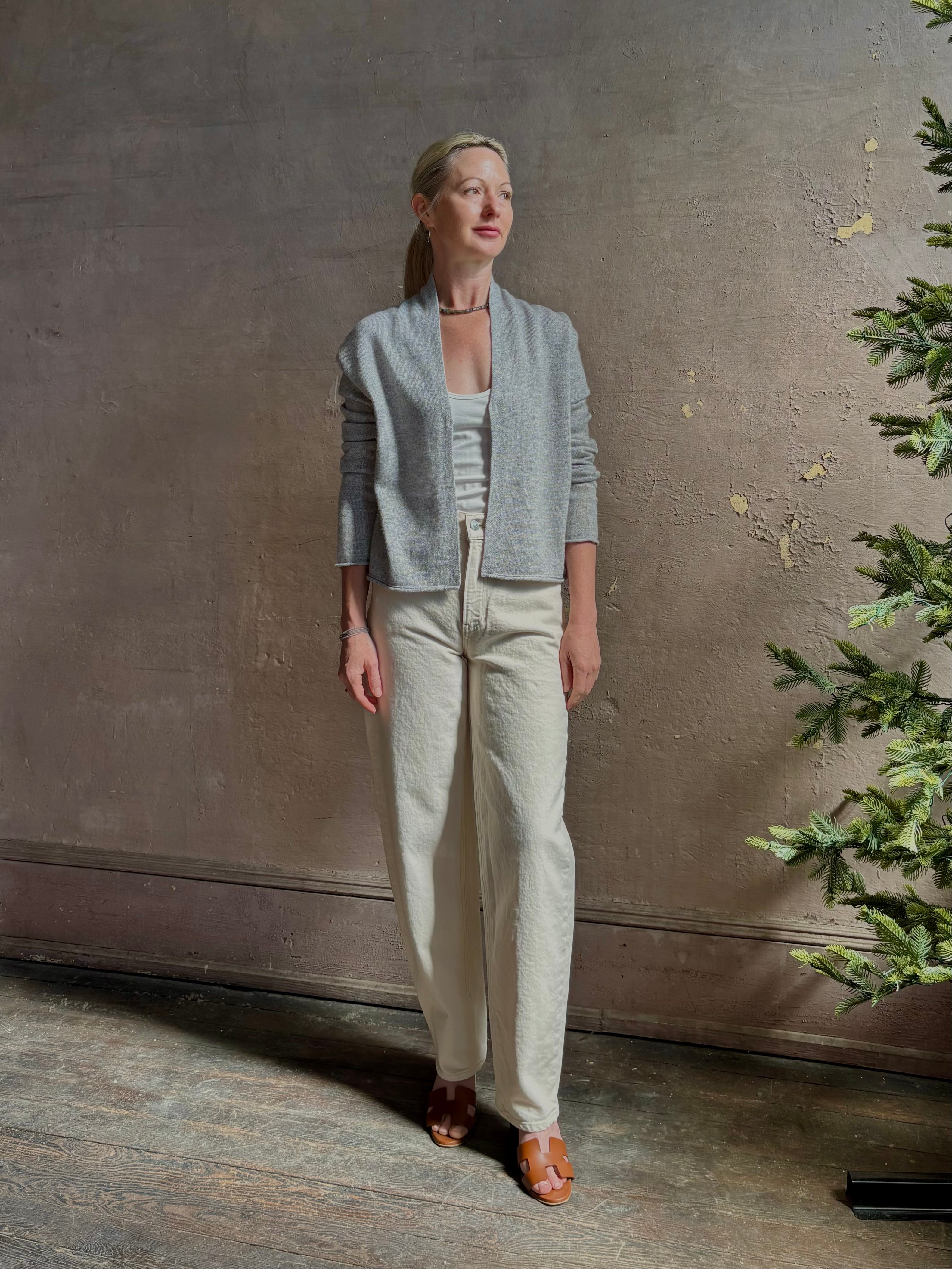 Mature woman wearing comfortable stone grey cashmere linen GUEST IN RESIDENCE Stealth long sleeve crop Cardigan with single hook and eye front closure crafted in a neutral stone grey