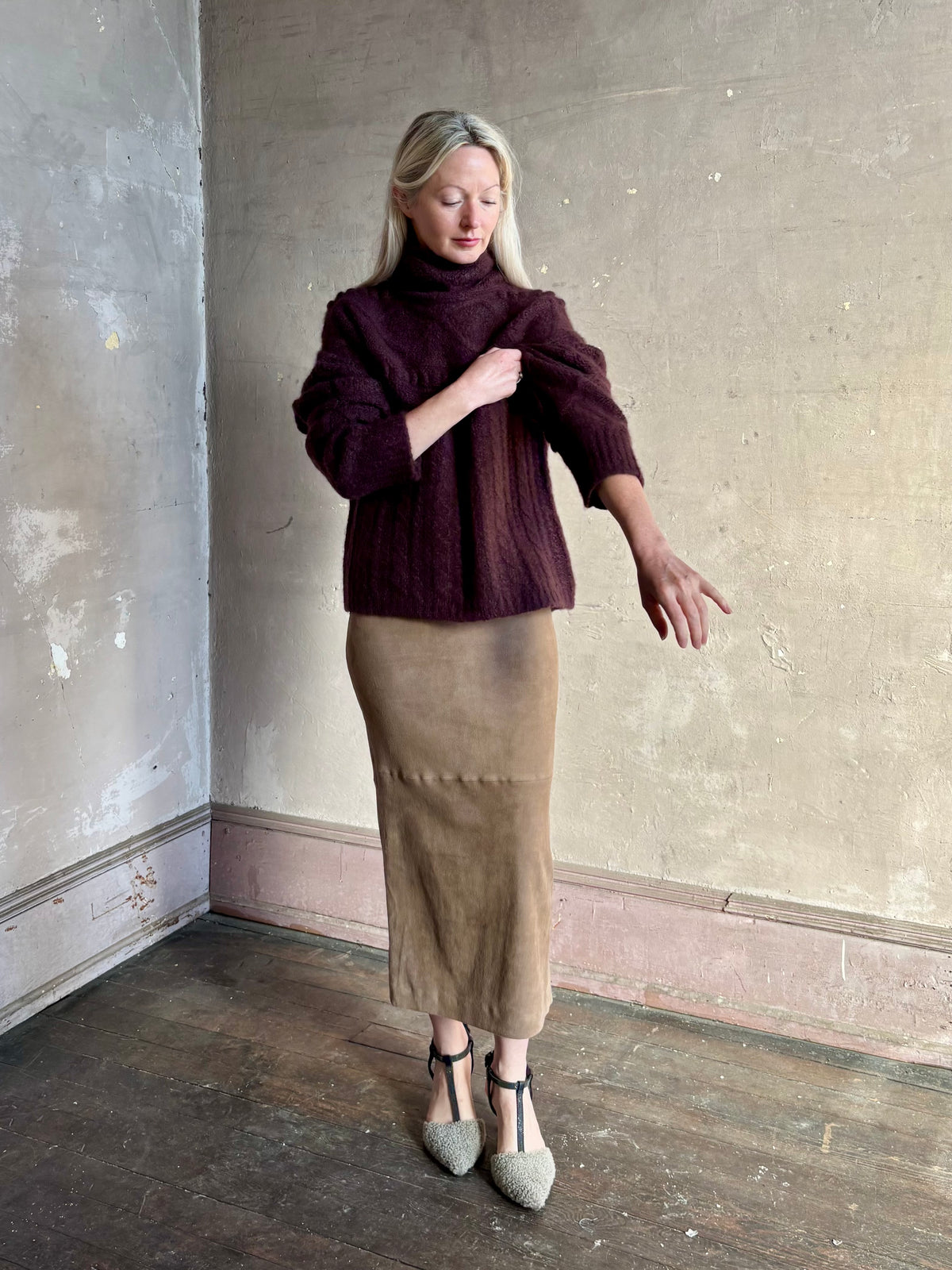 Mature woman wearing Guest in Residence’s Super Cloud T Neck in Fig cashmere-silk boucle knit with cable pattern and funnel neck