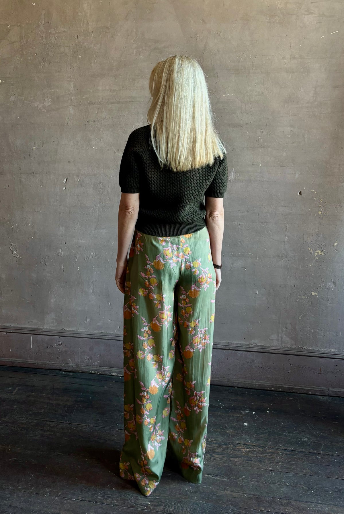 Mature woman wearing Hannah Artwear Azra silk Pant Khaki habotai with vibrant pomegranate print relaxed straight leg Fluid artisan-printed