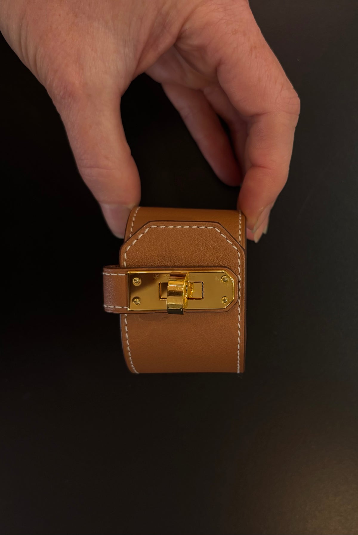 Hermès Kelly Twist Bracelet Brown & Yellow Gold: swift leather gold-plated Kelly turn-lock hardware hand assembled in France Pristine never-worn collector icon