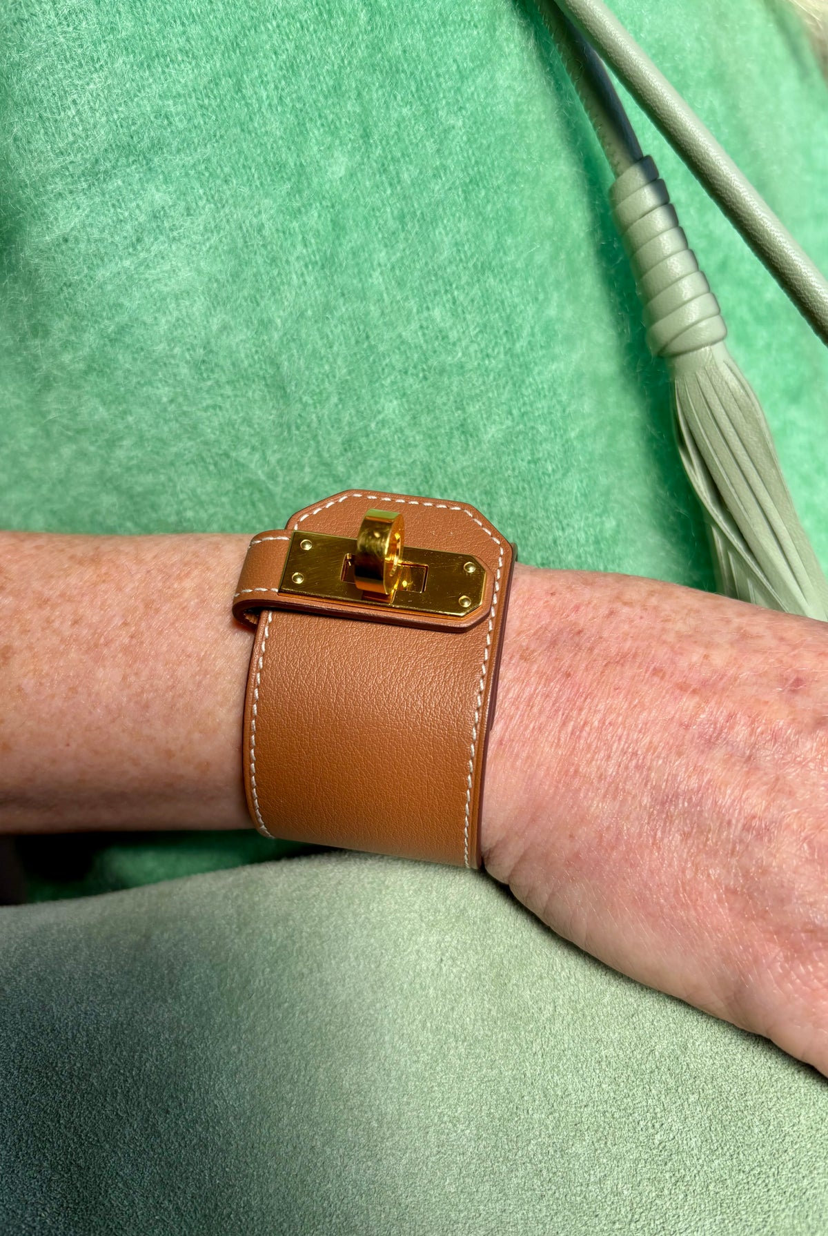 Hermès Kelly Twist Bracelet Brown & Yellow Gold: swift leather gold-plated Kelly turn-lock hardware hand assembled in France Pristine never-worn collector icon
