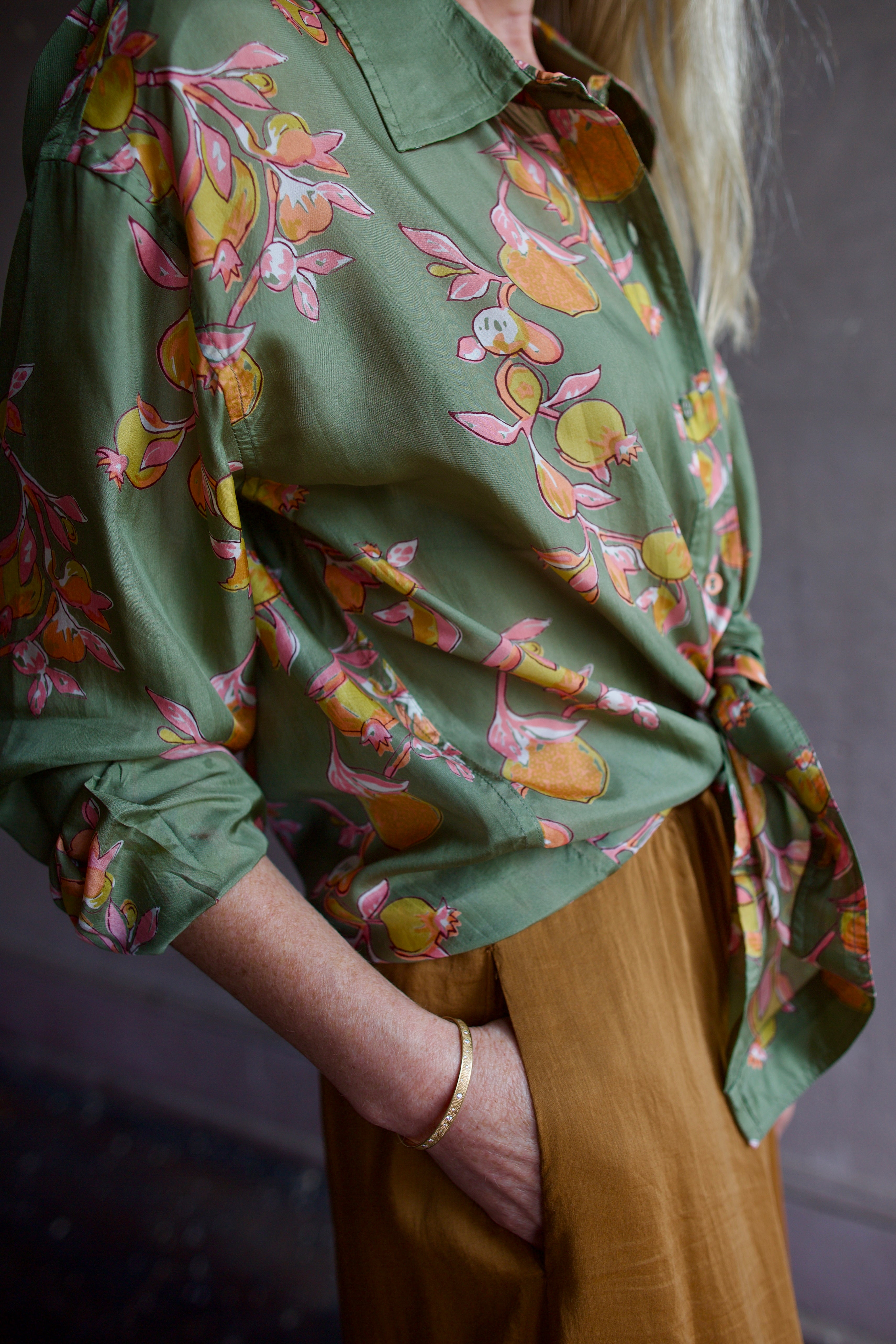 Close up image of a woman wearing the Hannah Artwear Stevie Shirt and Forte Forte Skirt