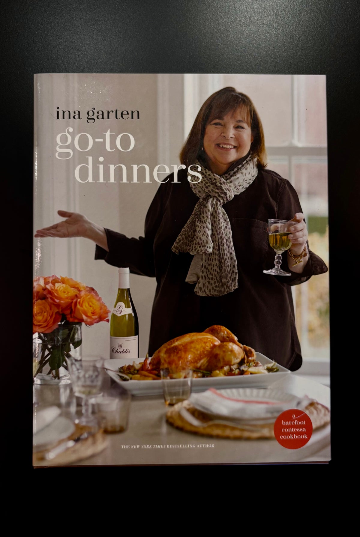 image of 'Go-To Dinners' cookbook by Ina Garten, featuring Ina holding a glass of white wine next to a roasted turkey